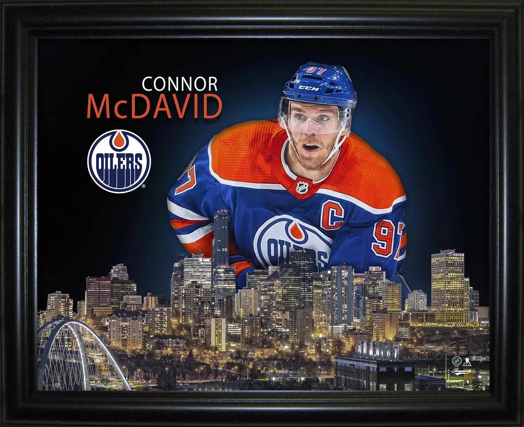 Edmonton Oilers player in blue and orange jersey above city skyline, Oilers logo, framed art