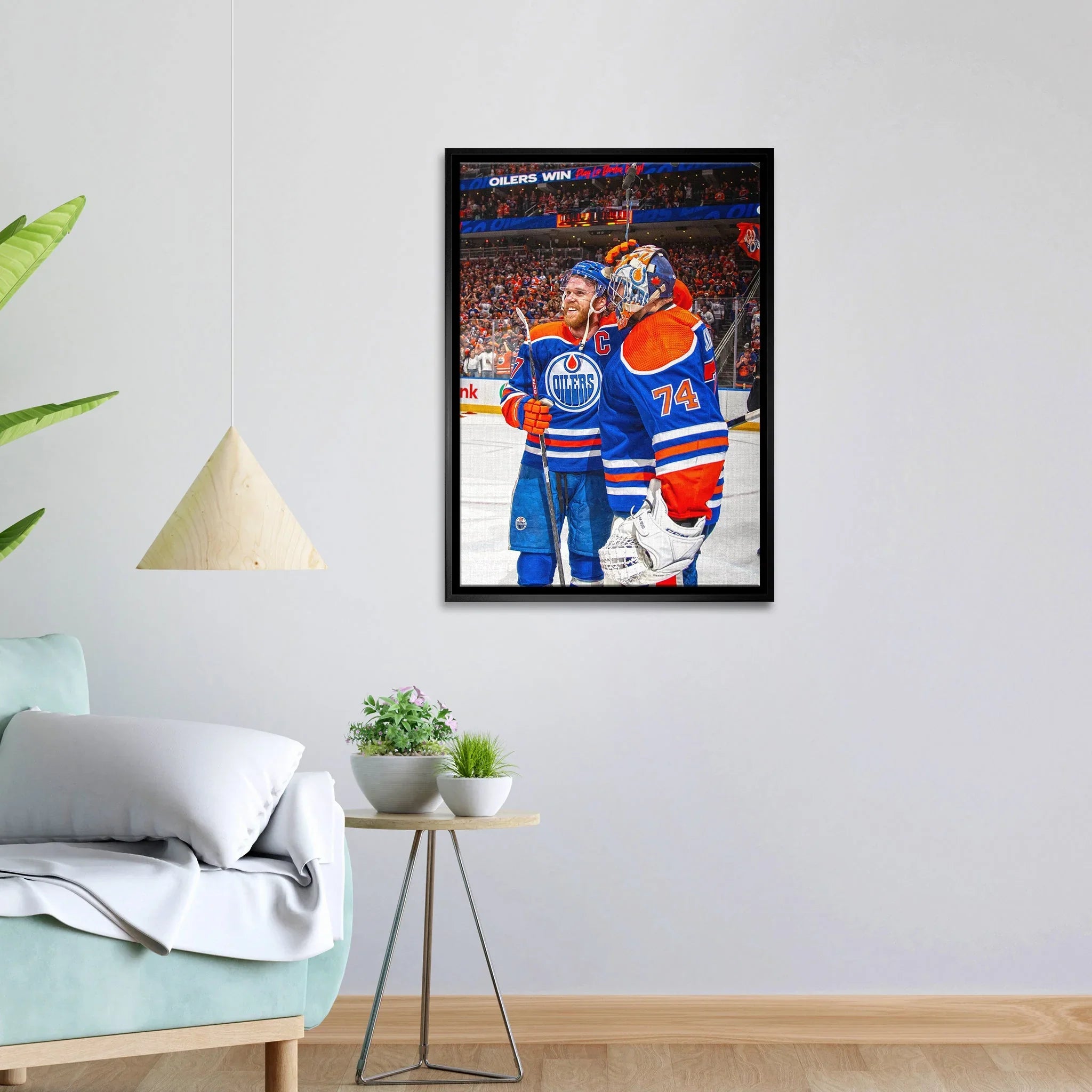 Framed Edmonton Oilers hockey art on wall above modern sofa and plant decor