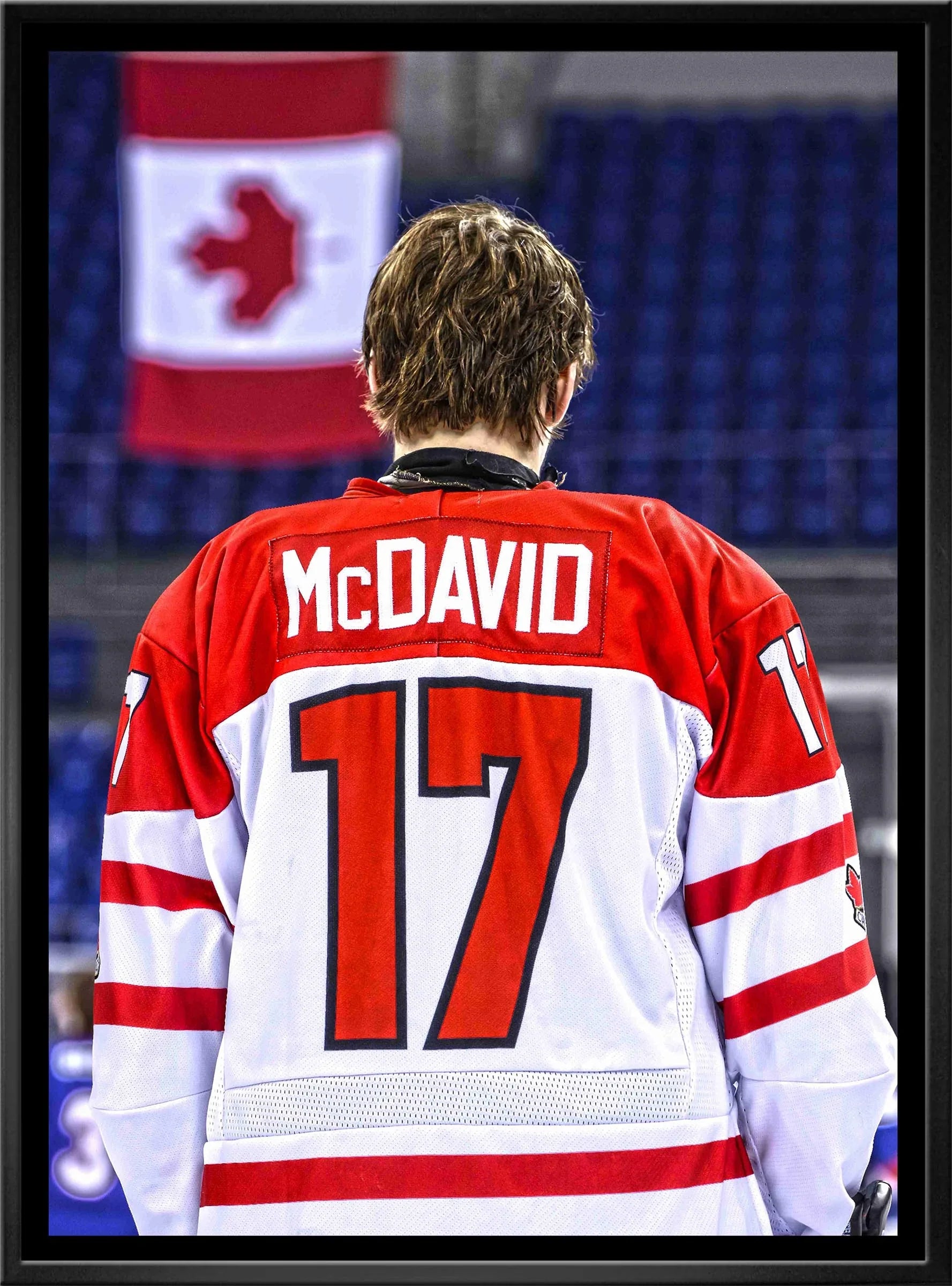 Hockey player in red and white McDavid 17 jersey with Canadian flag background