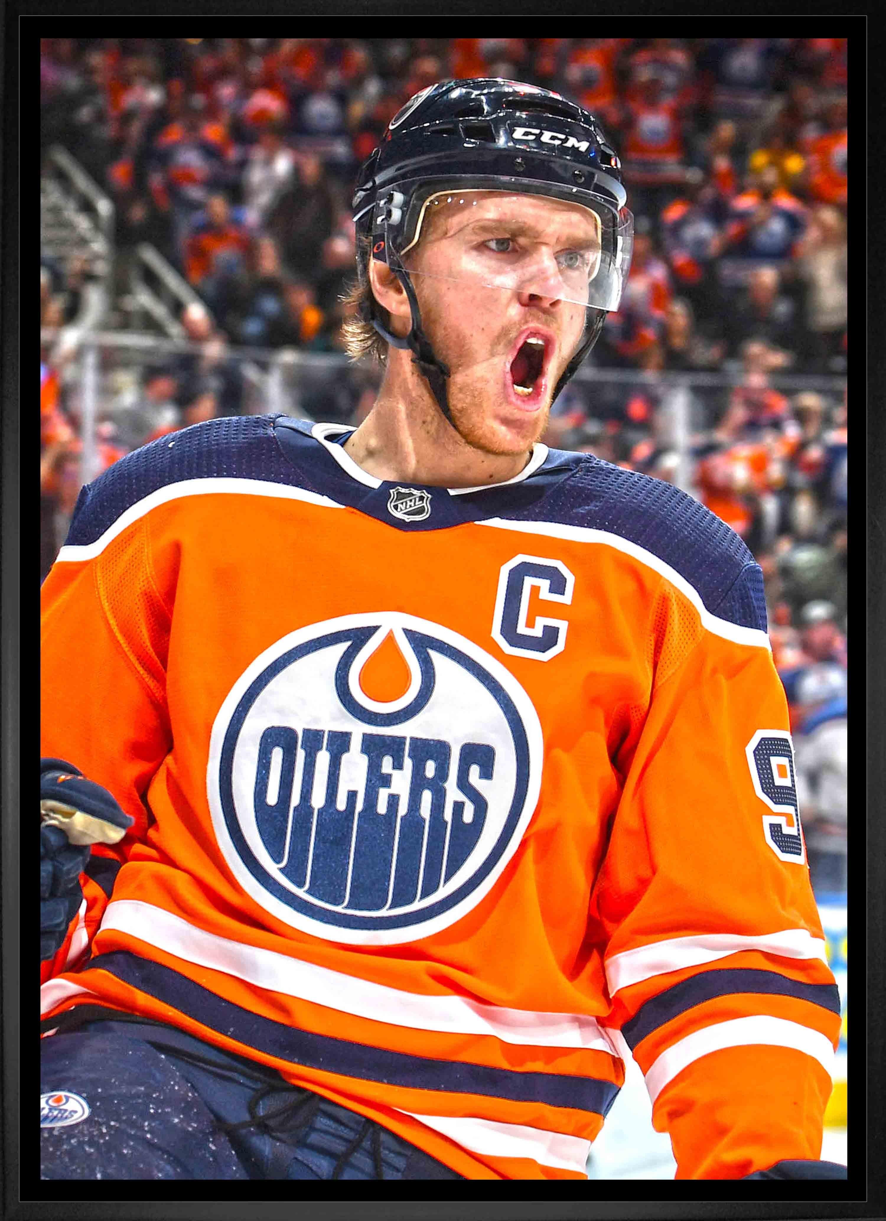 Edmonton Oilers hockey player in orange jersey celebrating on ice