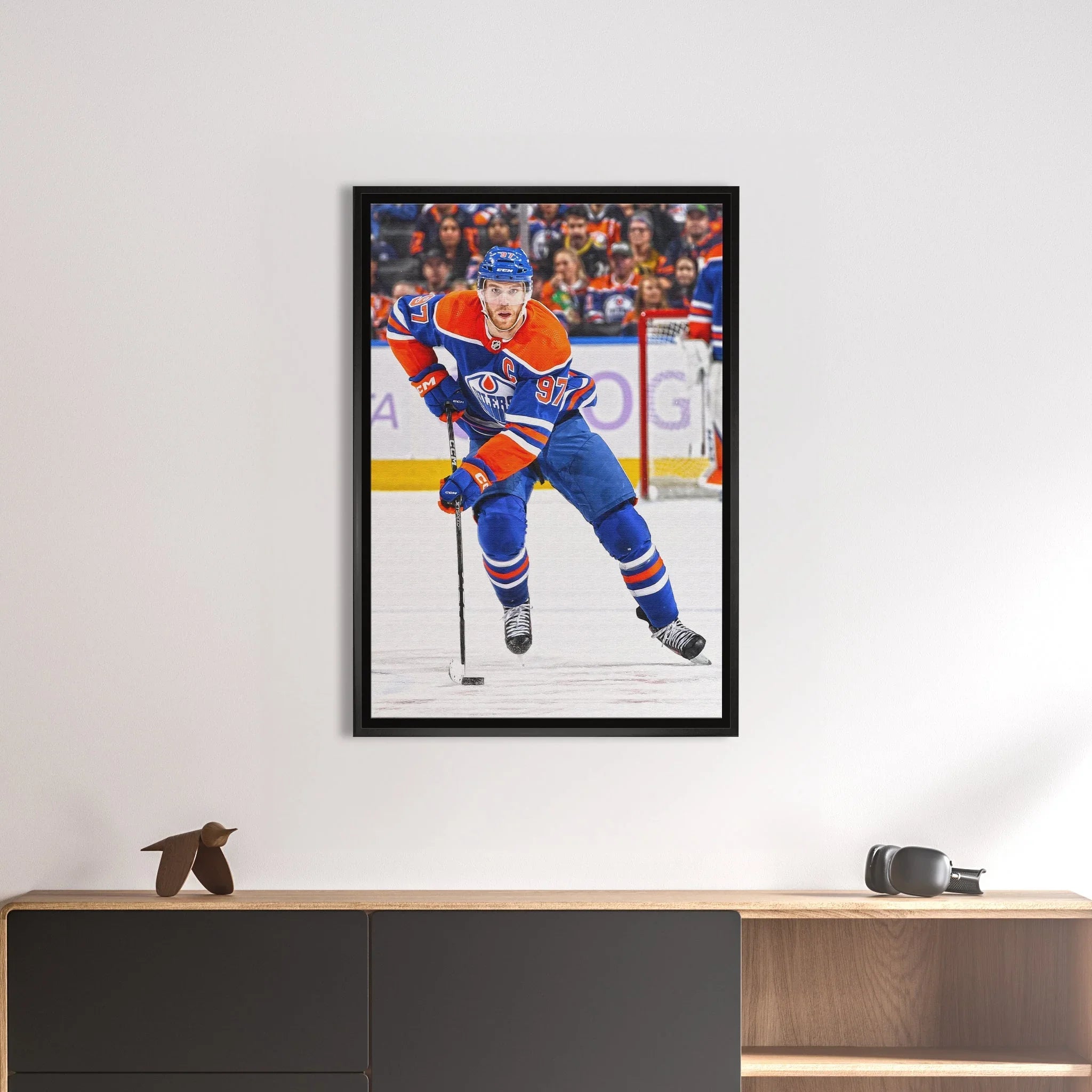 Framed ice hockey player wall art, Edmonton Oilers uniform, displayed above modern console