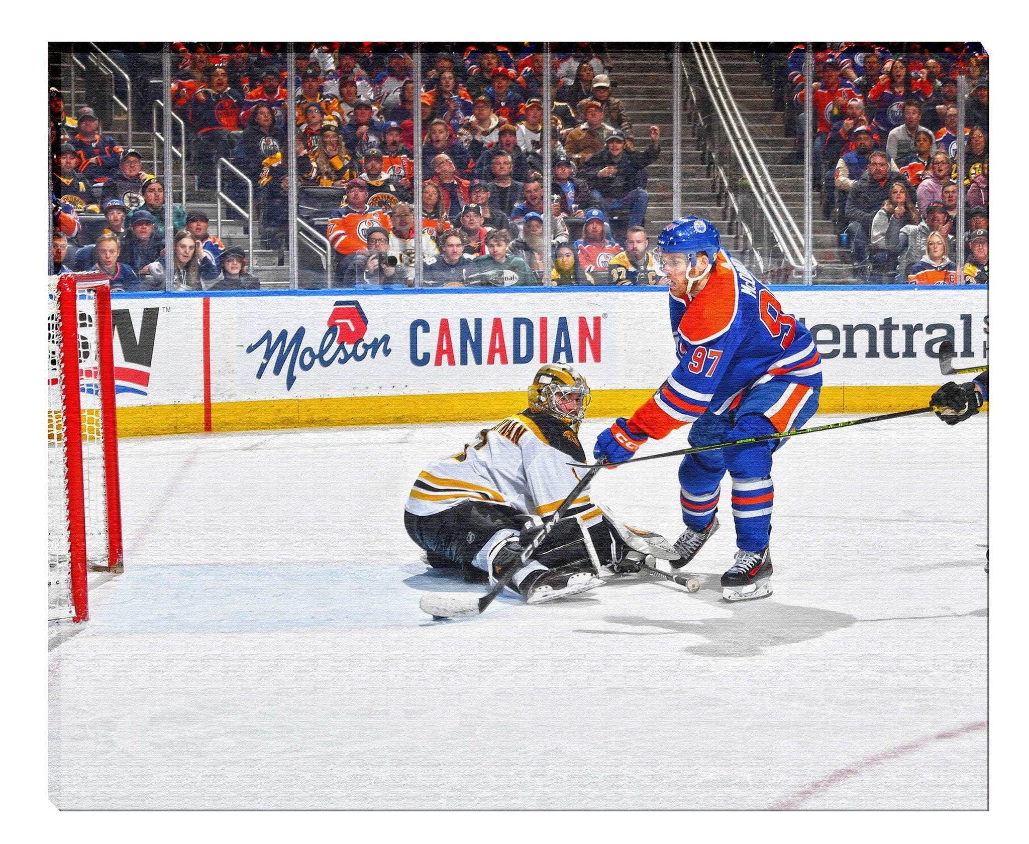 Edmonton Oilers player shoots on Boston Bruins goalie during NHL hockey game