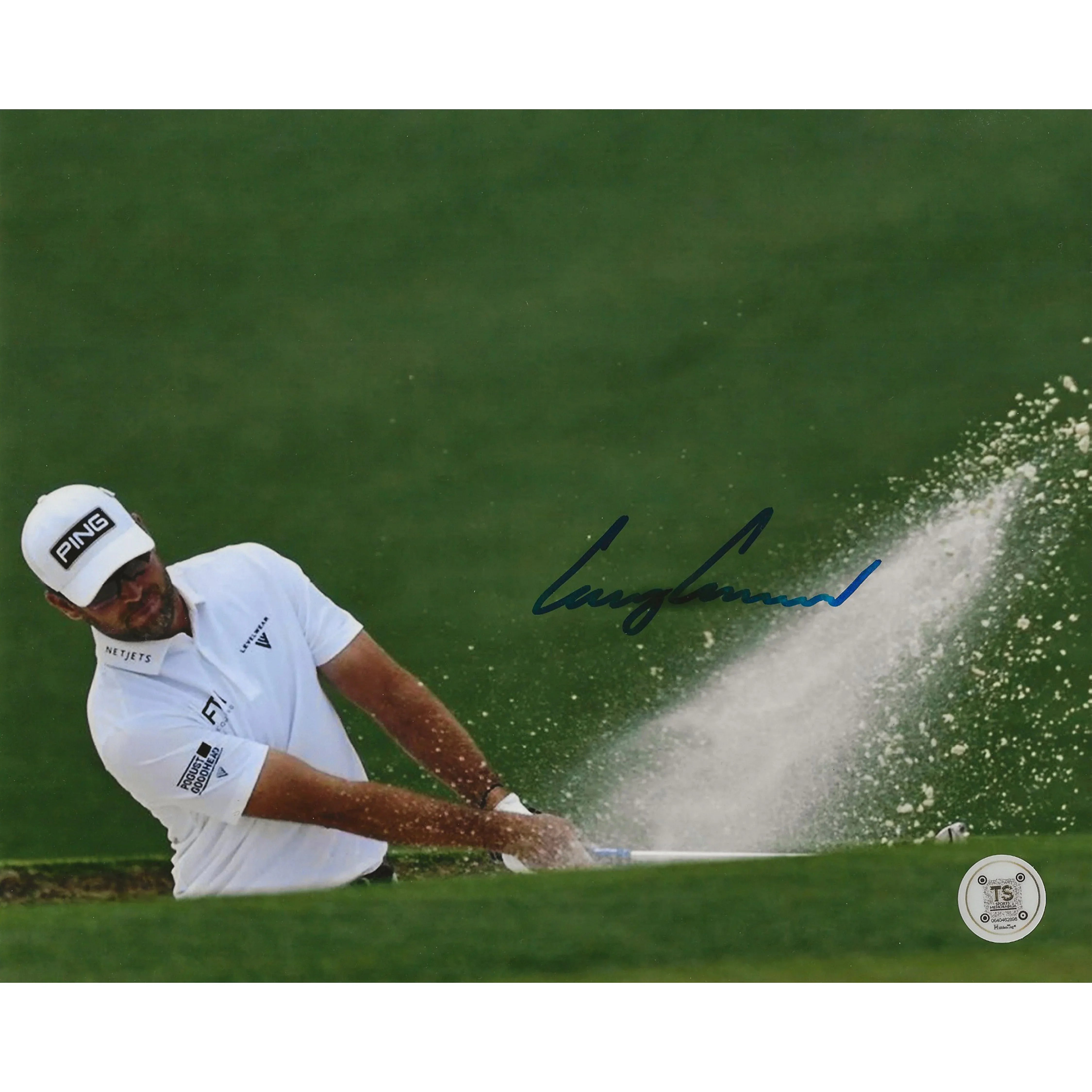 Golfer hitting a bunker shot on green grass, PING hat, sand spray, autograph visible