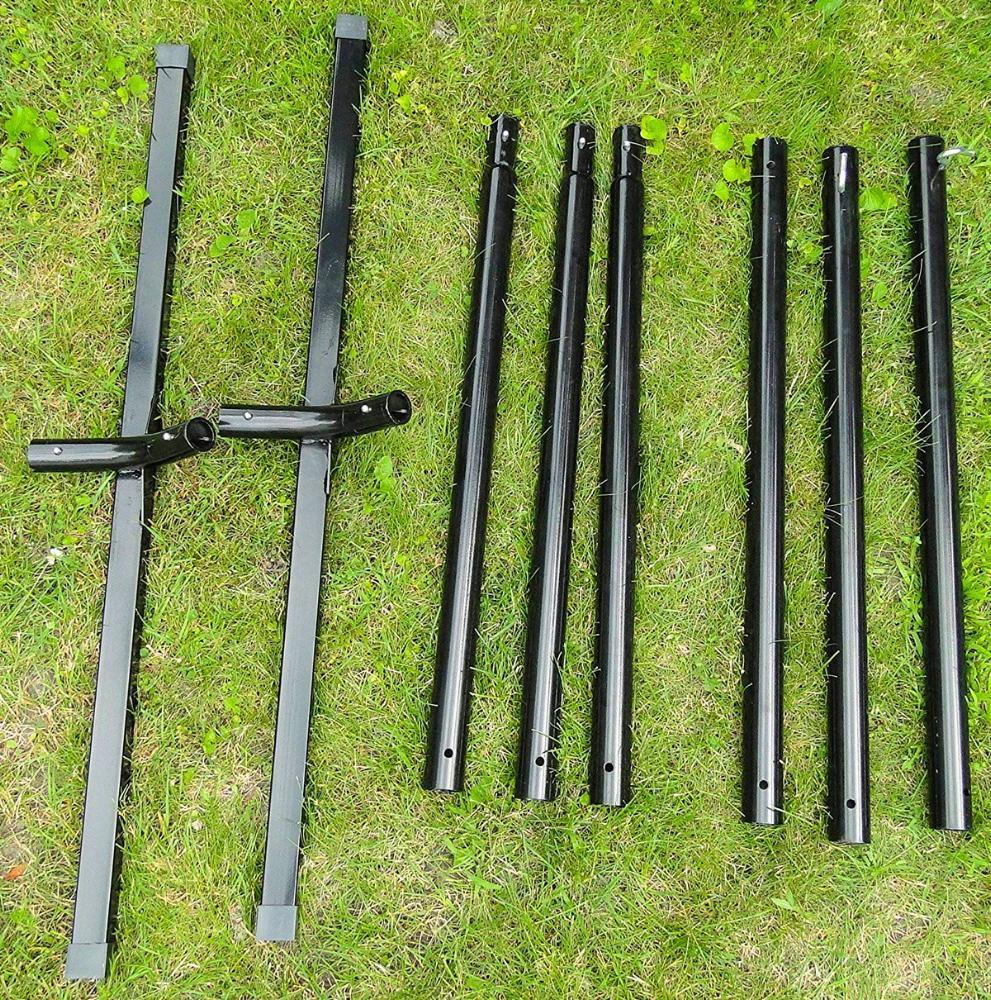 Black steel tri-beam hammock stand parts laid out on green grass