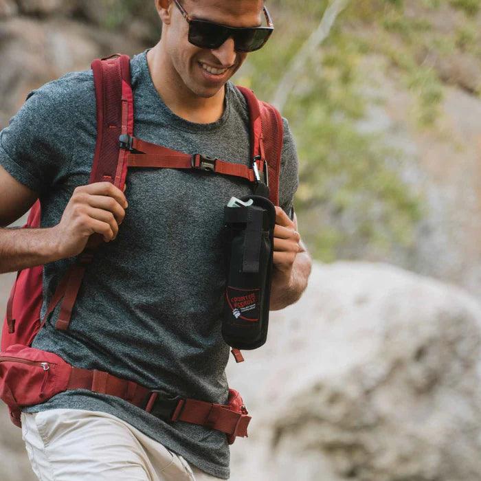 Hiker wearing sunglasses and red backpack with black backpacker holster outdoors