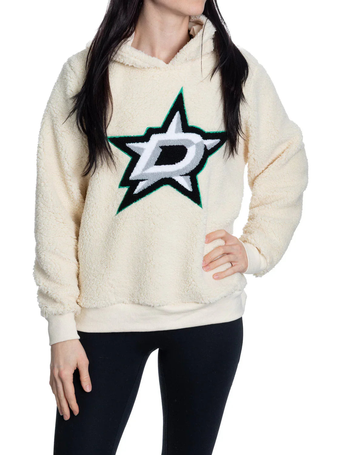 Woman wearing cream sherpa Dallas Stars hoodie with large team logo, black leggings