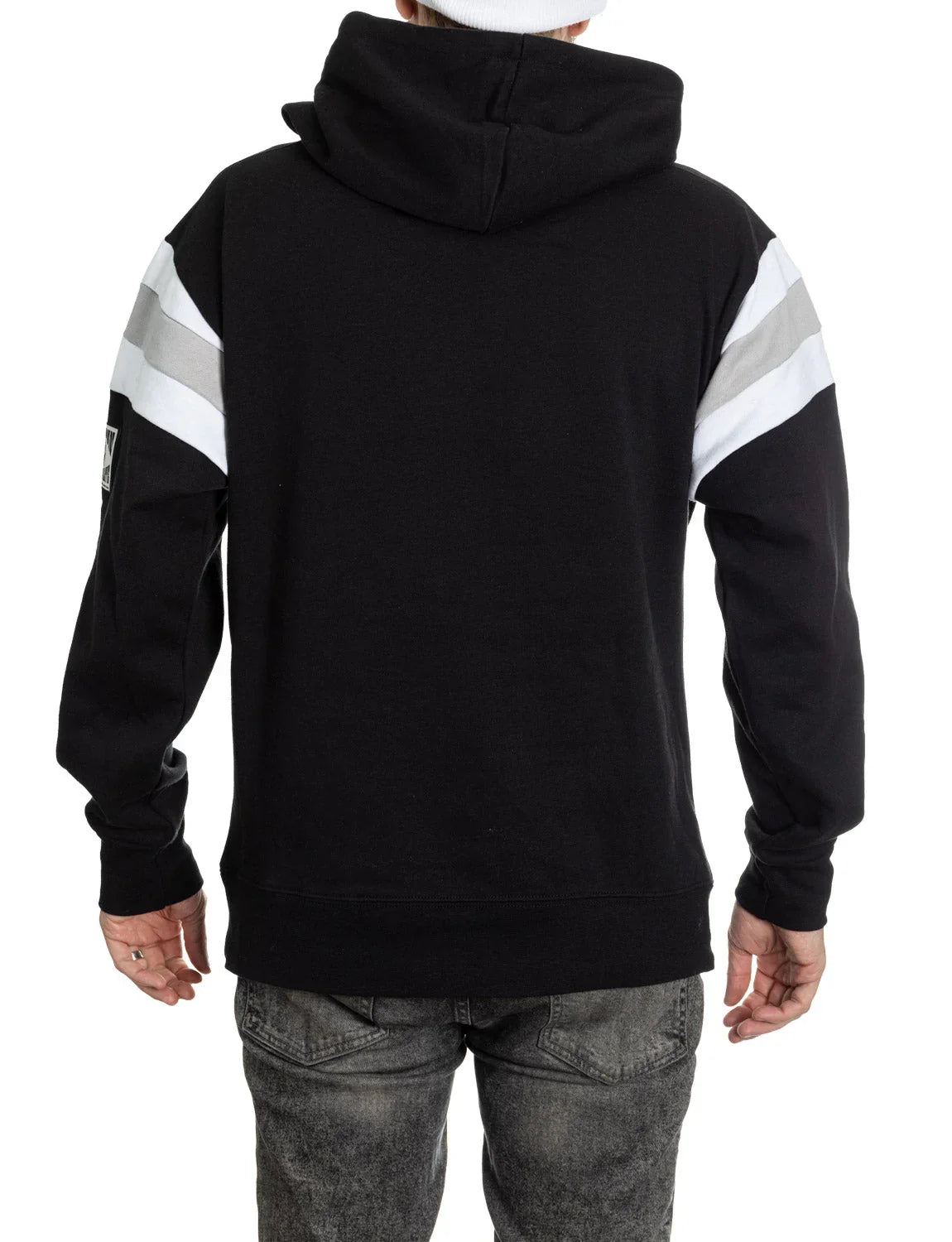 Back view of man wearing black varsity hoodie with white and gray stripes on sleeves