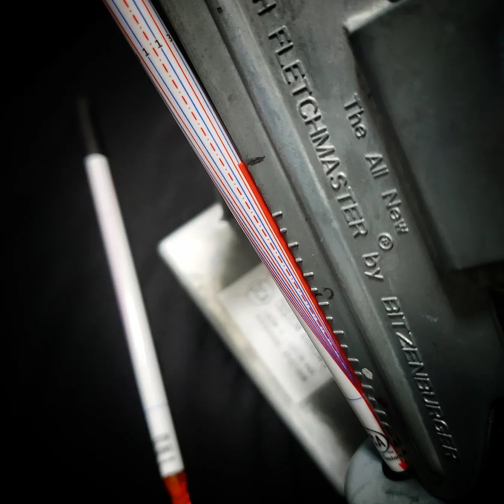 Close-up of arrow fletching tool with arrow shaft, Bitzenburger Fletchmaster detail visible