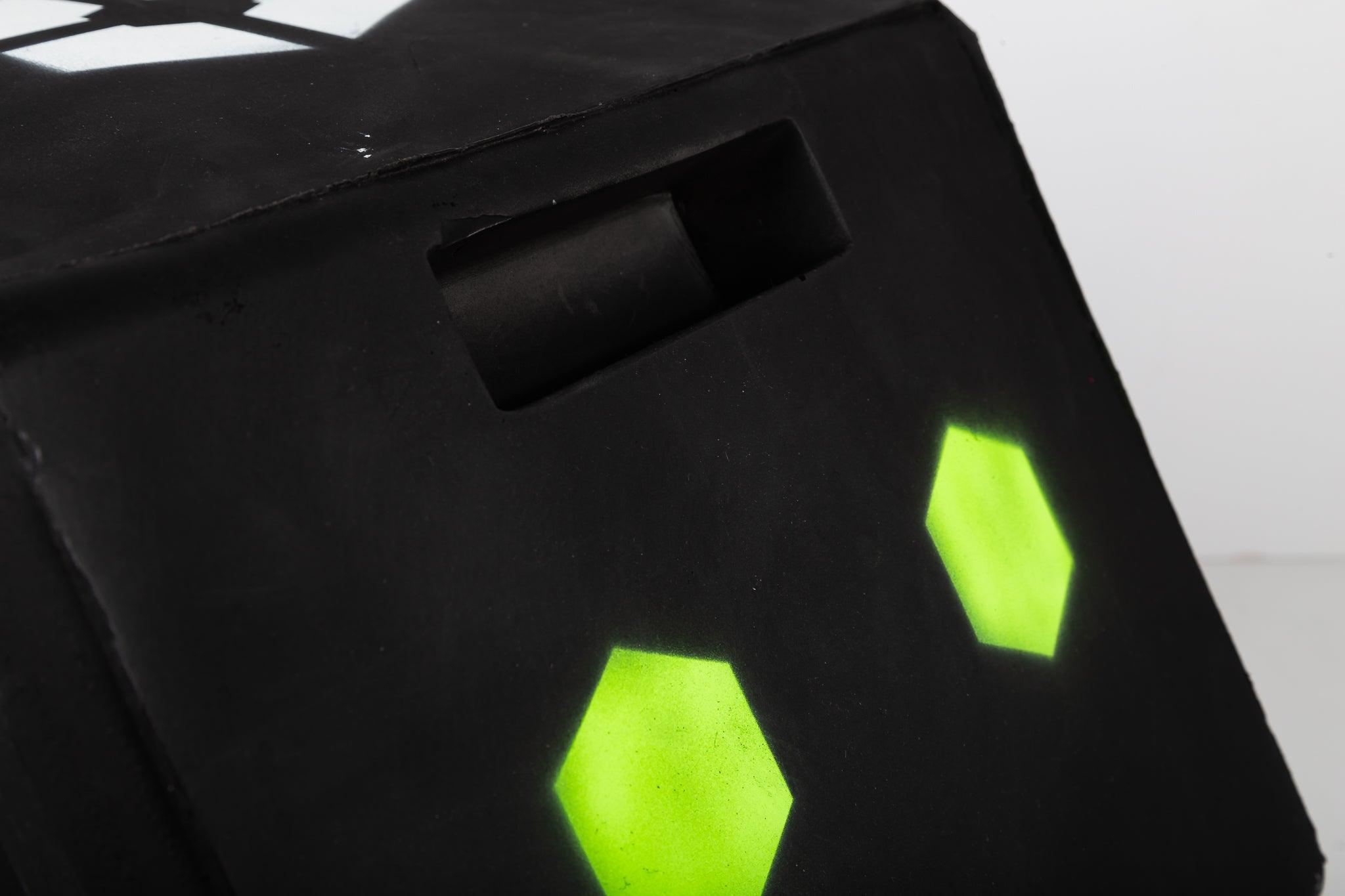 Black foam handle with neon green hexagon shapes and cutout grip on surface