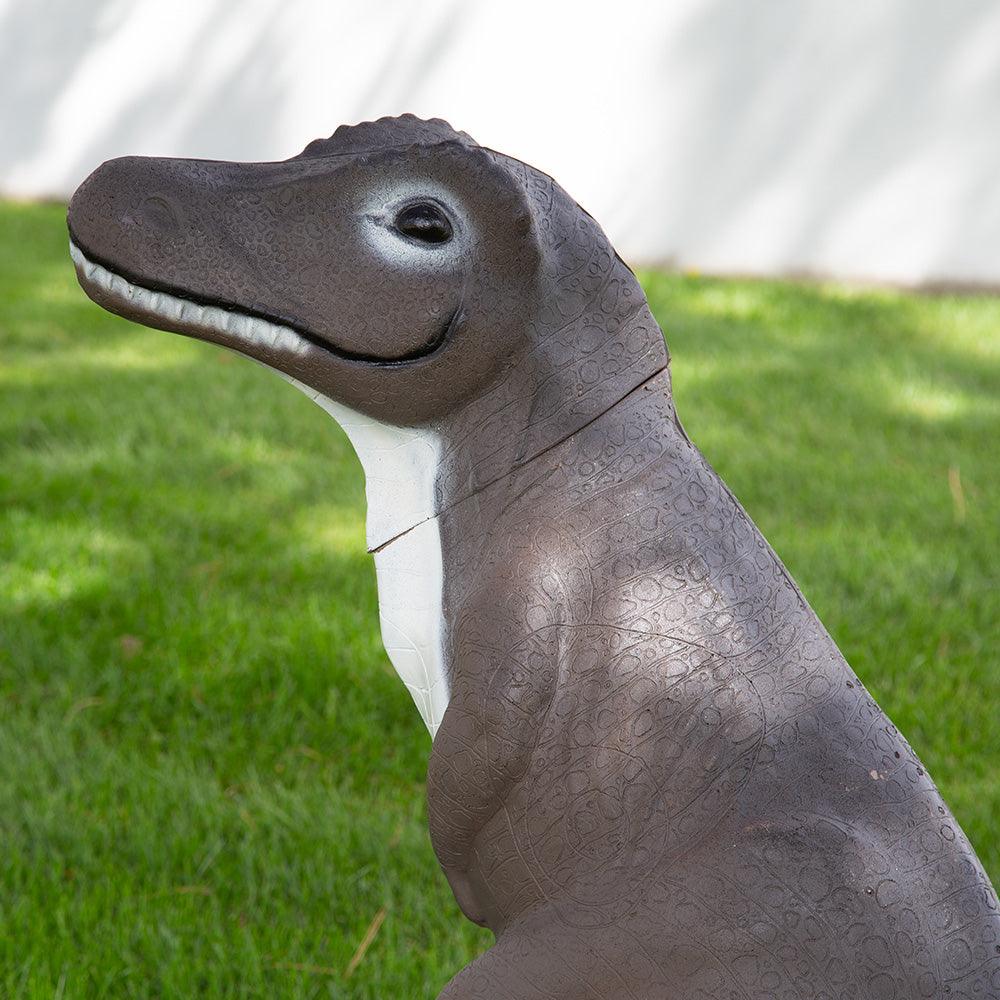 Realistic brown dinosaur statue on green grass, outdoor garden decor