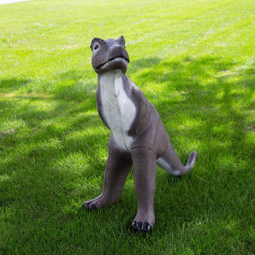 Realistic brown dinosaur statue on green grass outdoors