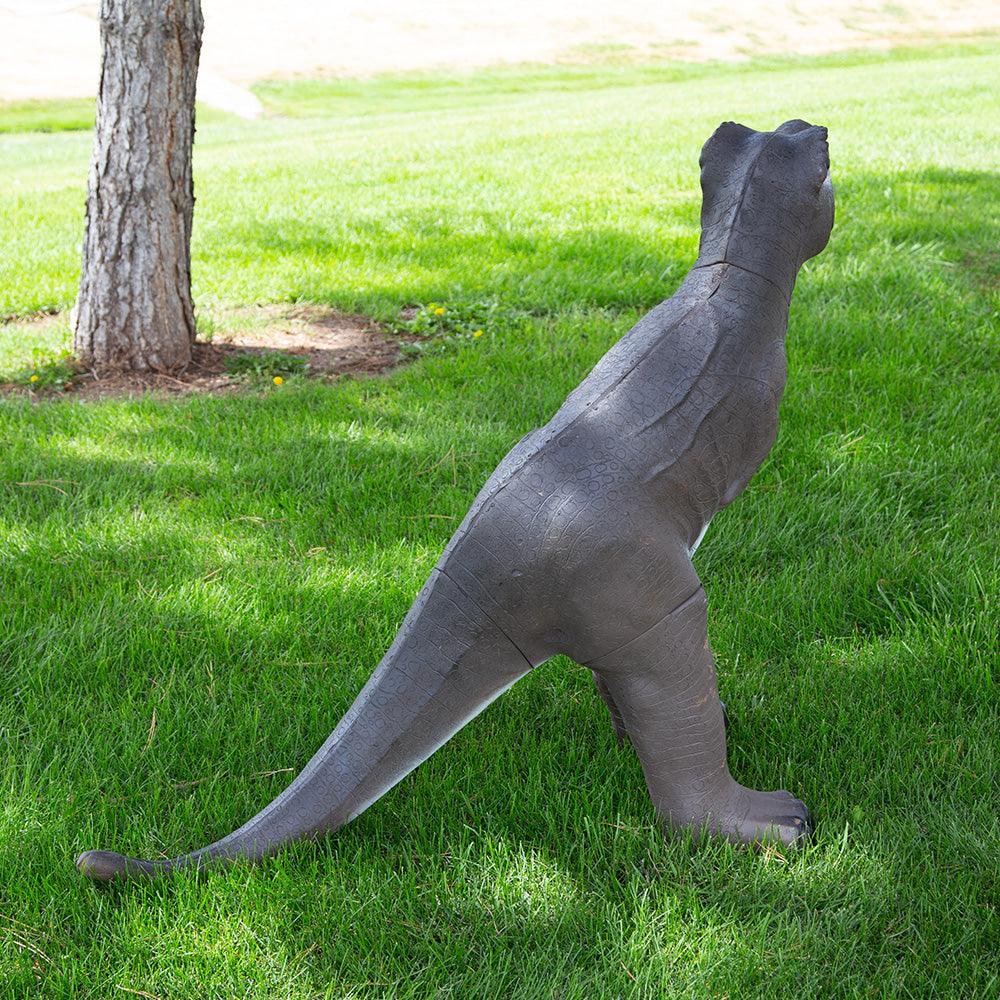 Realistic dinosaur yard statue on green grass beside a tree, outdoor garden decor