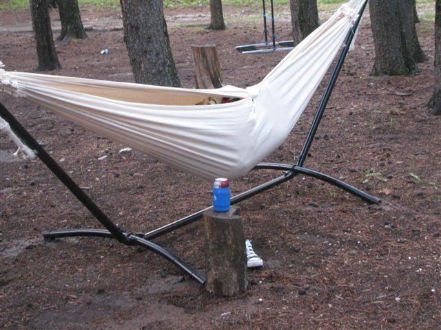 Brazilian universal hammock stand combo in outdoor forest setting with trees and a soda can nearby