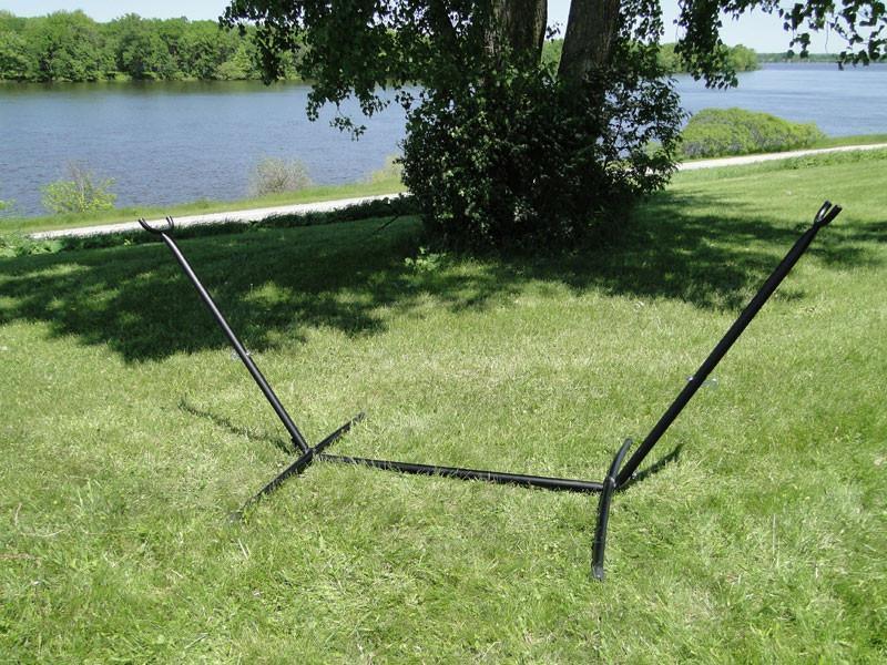 Universal black hammock stand on green grass by lakeside under tree shade outdoors
