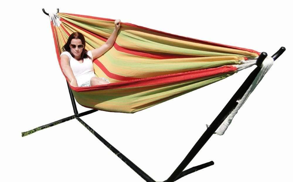 Woman relaxing in a red, yellow, and green double hammock with universal stand