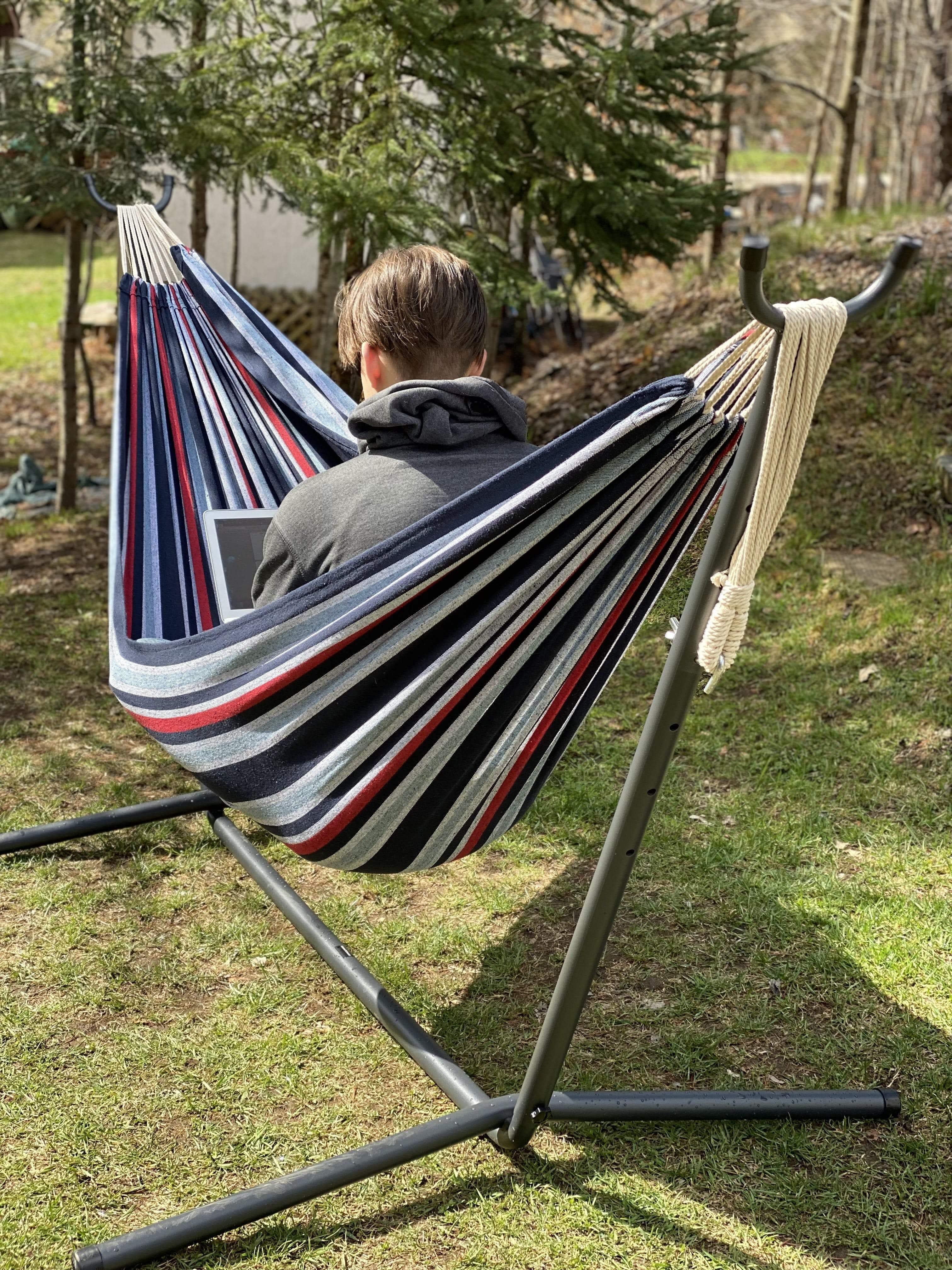 Person in striped Brazilian double denim hammock on stand outdoors