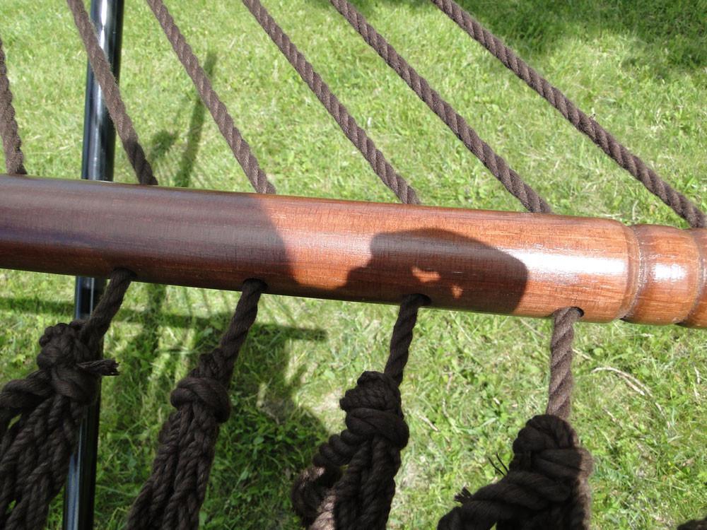 Close-up of deluxe polyester rope hammock with wooden spreader bar on green grass