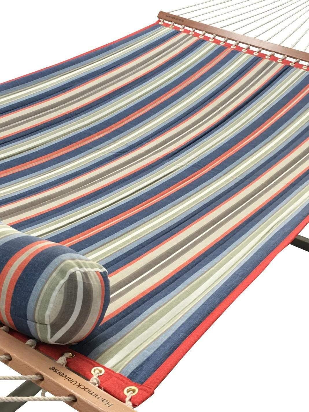 Quilted hammock with red, blue, green, and beige stripes and a matching rolled pillow
