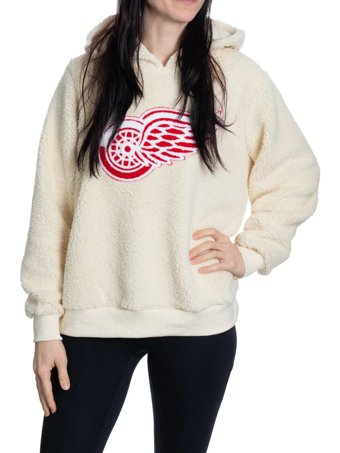 Woman wearing cream sherpa hoodie with red Detroit Red Wings logo, white background