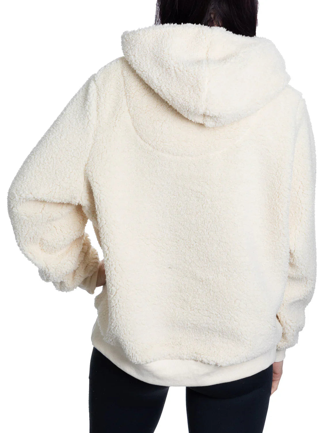 Back view of person wearing cream sherpa fleece hoodie and black pants