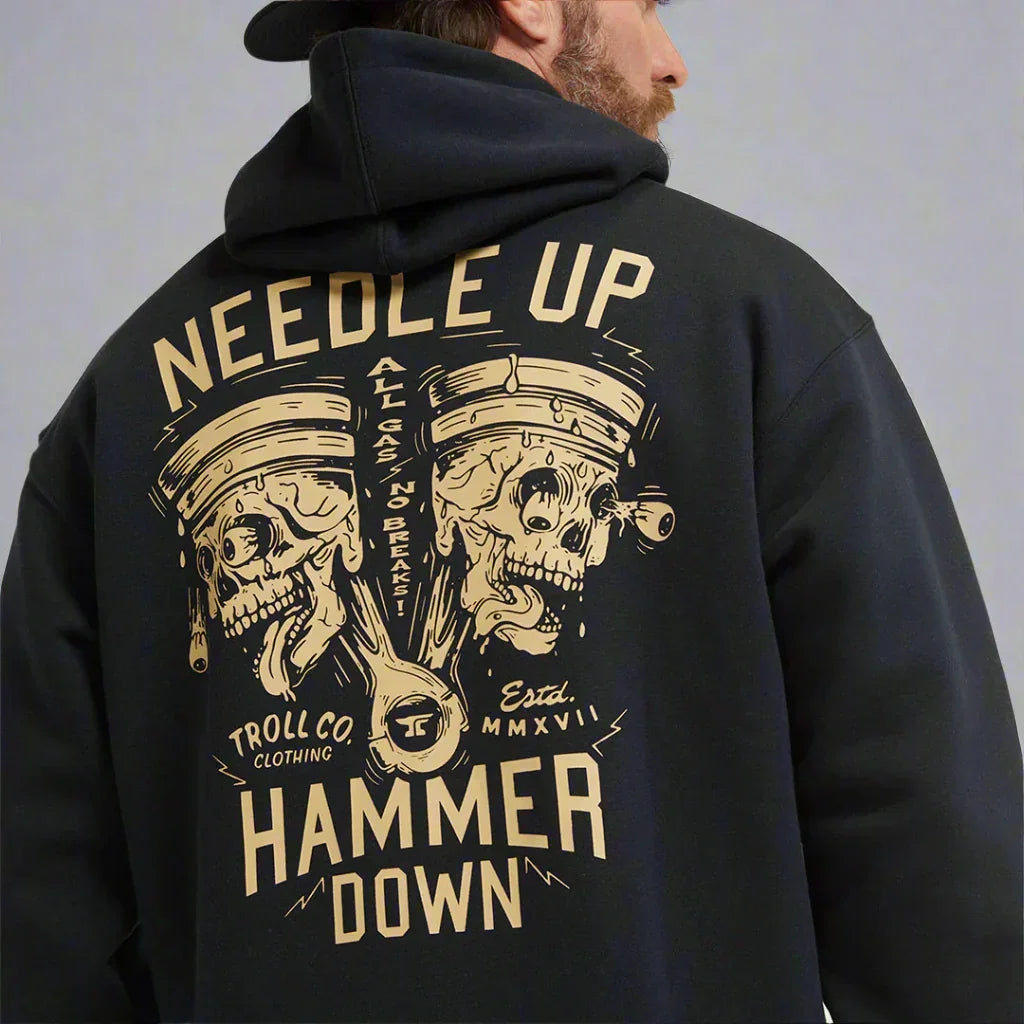 Man wearing black hoodie with illustrated skull piston graphic and 'Needle Up Hammer Down' text.