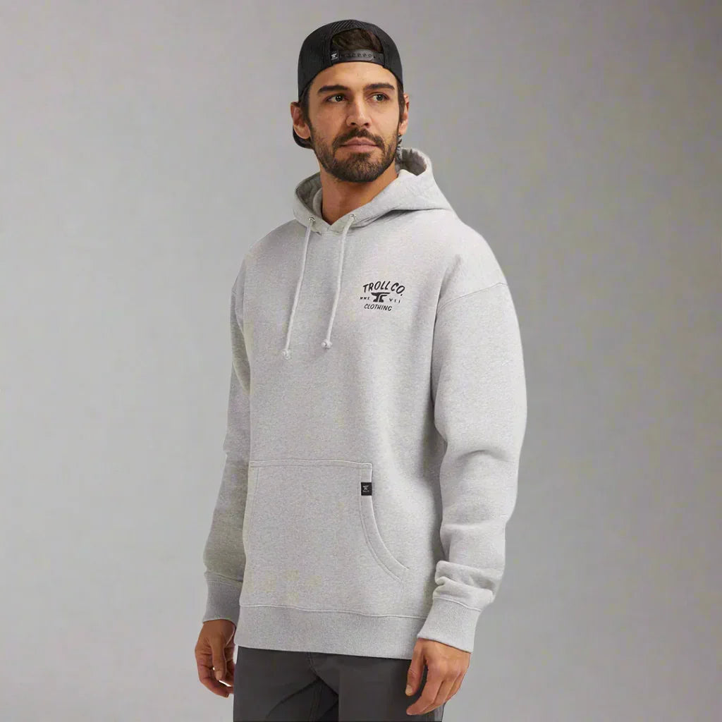 Man wearing light grey Troll Co. hoodie with front pocket and black cap