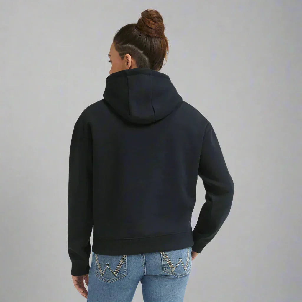 Back view of woman in black hoodie and blue jeans with embroidery