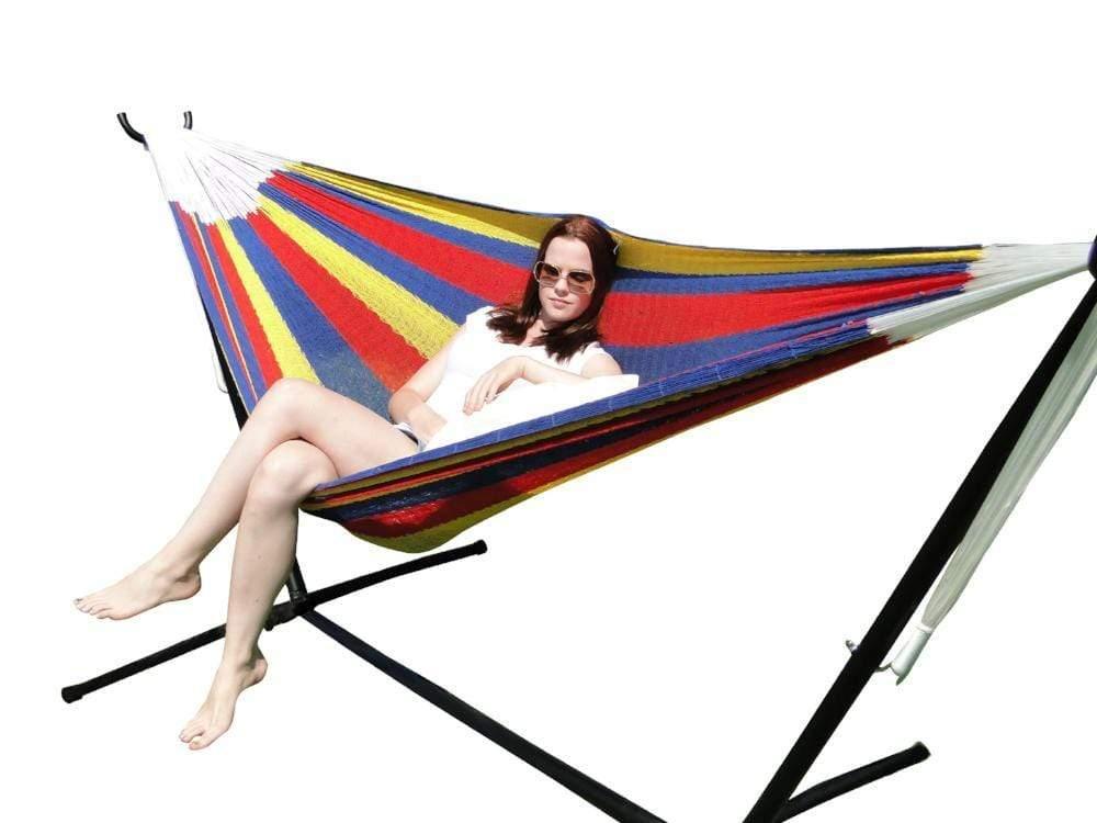Woman relaxing in multicolor striped hammock with stand on white background