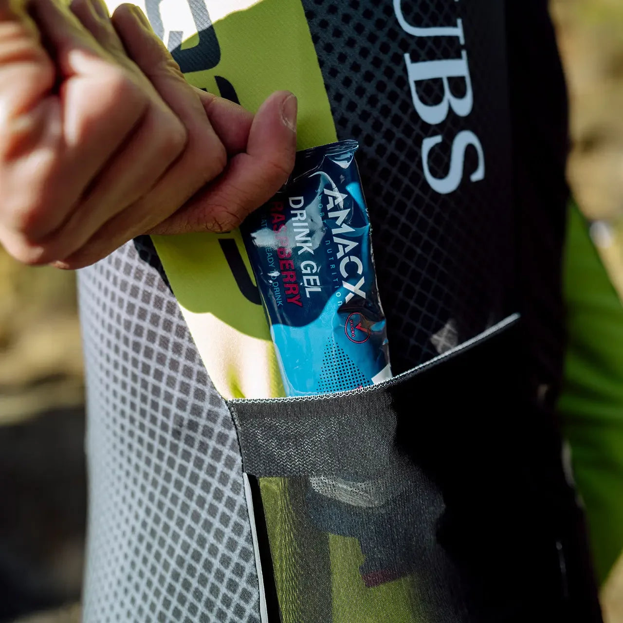 Amacx Drink Gel Raspberry in cyclist jersey pocket outdoors