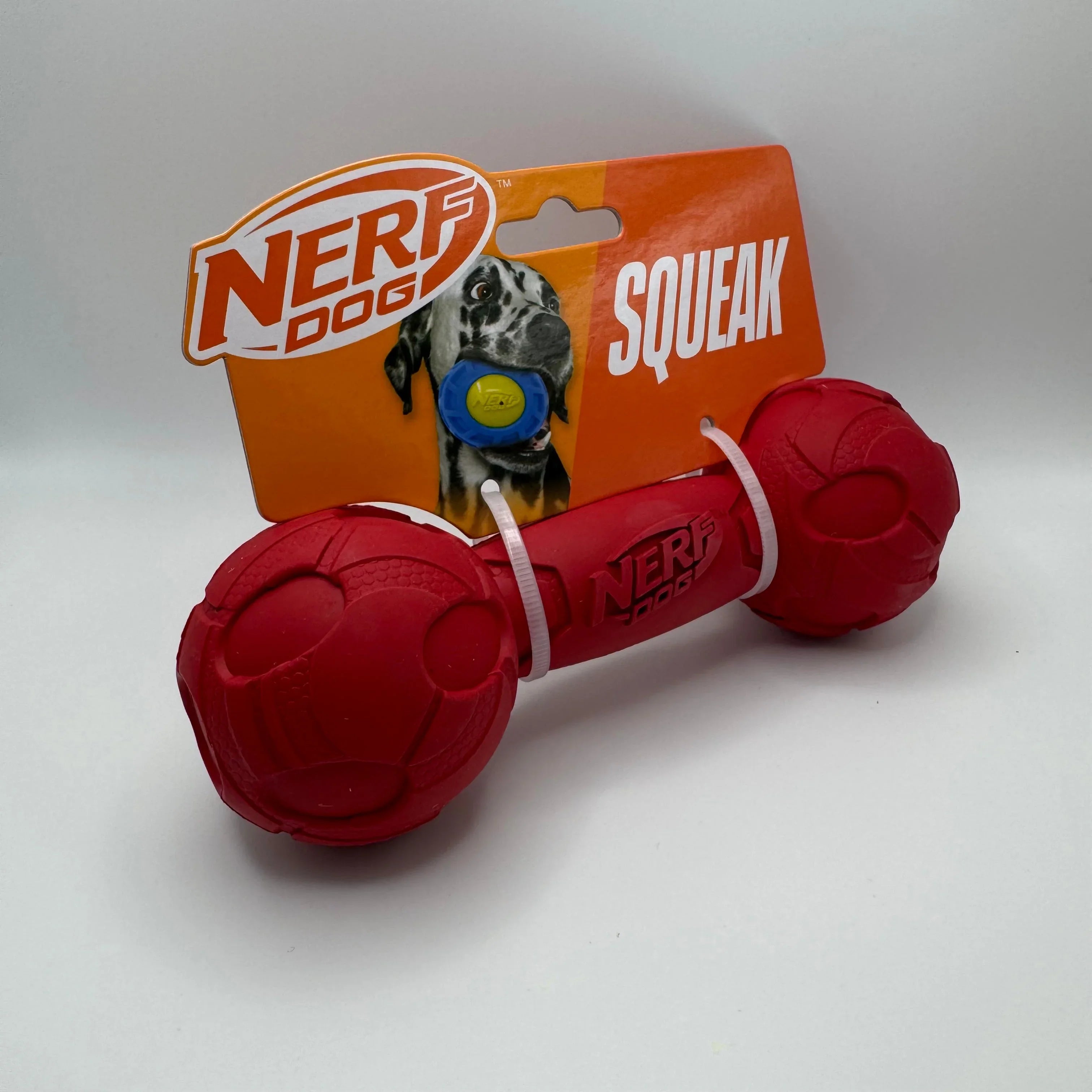 Red Nerf Dog squeak toy in packaging with orange label and dog image
