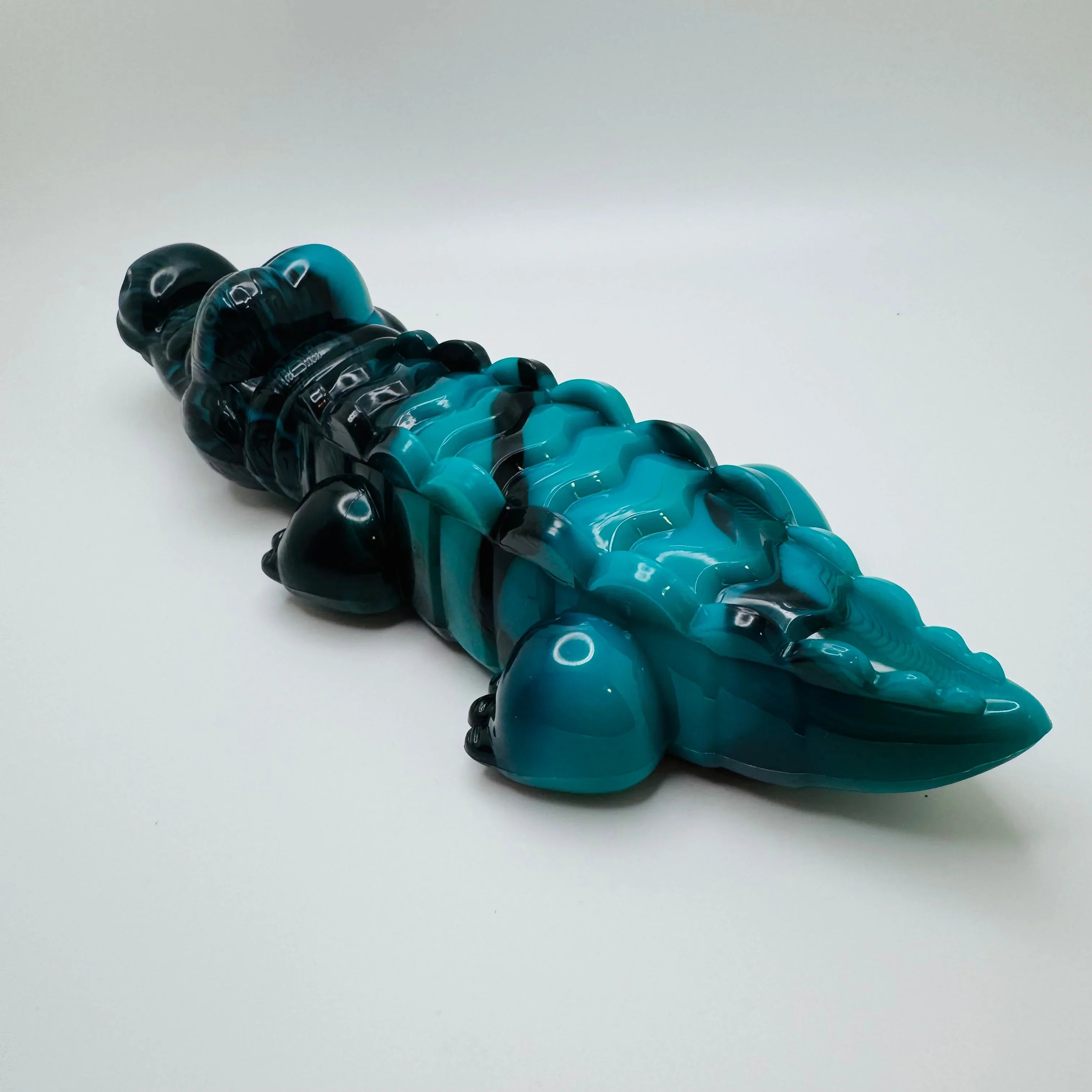 Blue and black resin alligator figurine toy on a white background