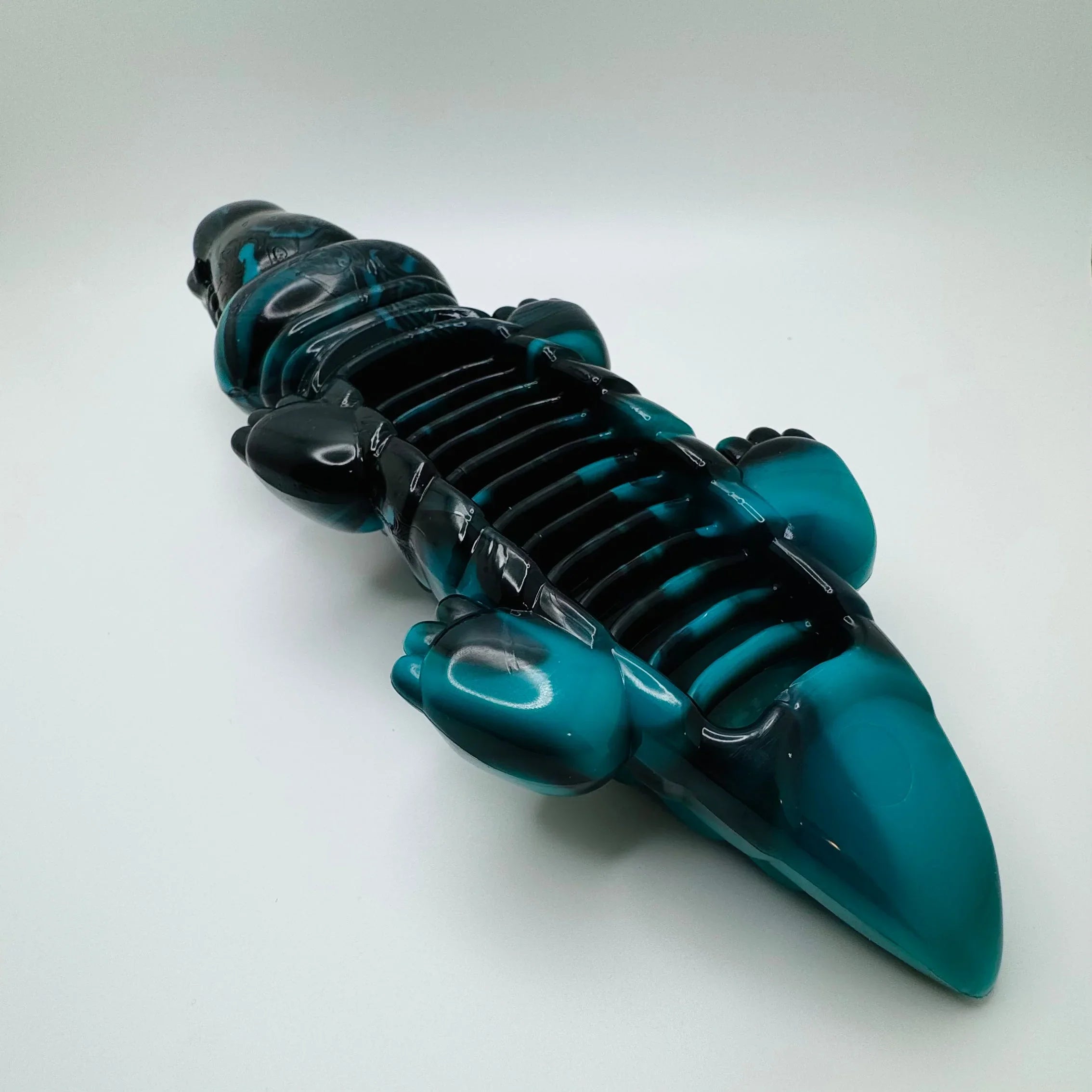 Blue and black alligator-shaped dog chew toy on white background