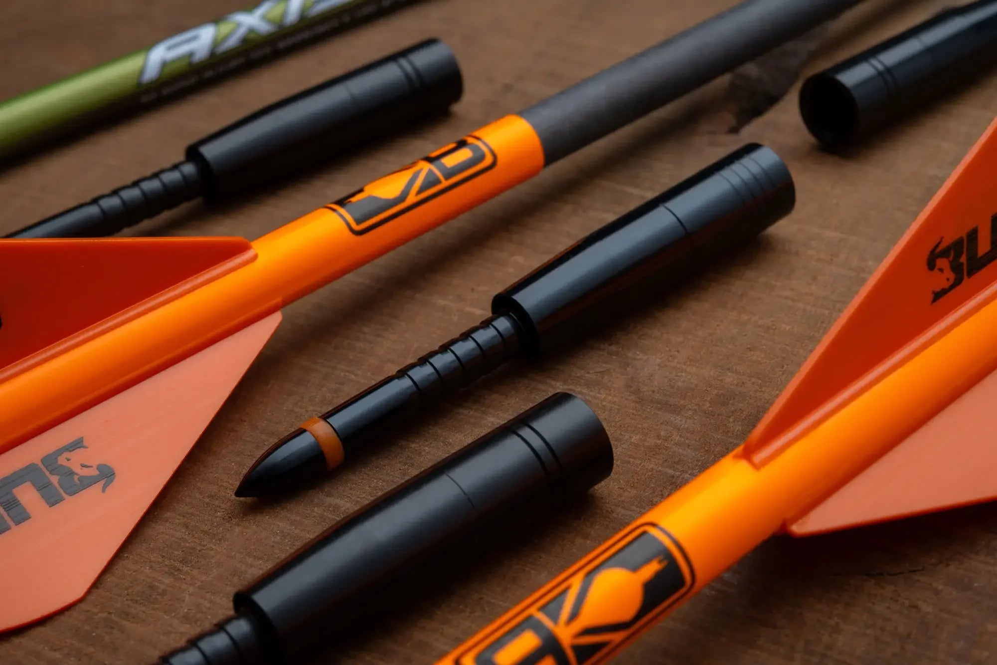4mm Matchgrade Halfout 55gr black arrow inserts with orange and green arrows on wood