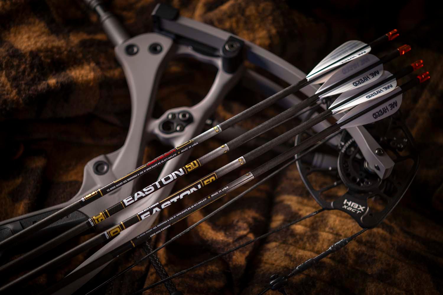 Easton carbon arrows on compound bow with camo background, archery equipment closeup