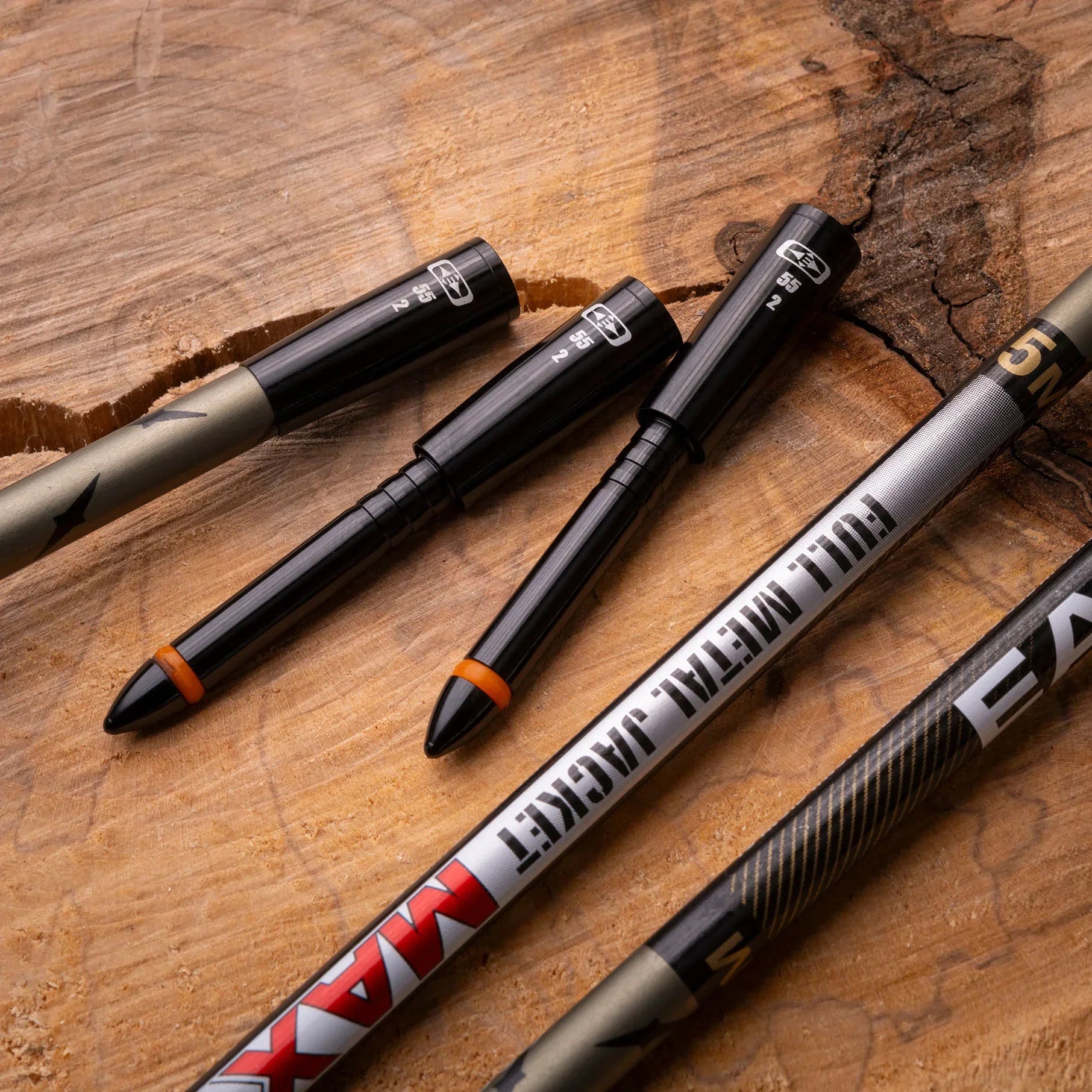 Full Metal Jacket Max arrow inserts and shafts on wood background, archery gear