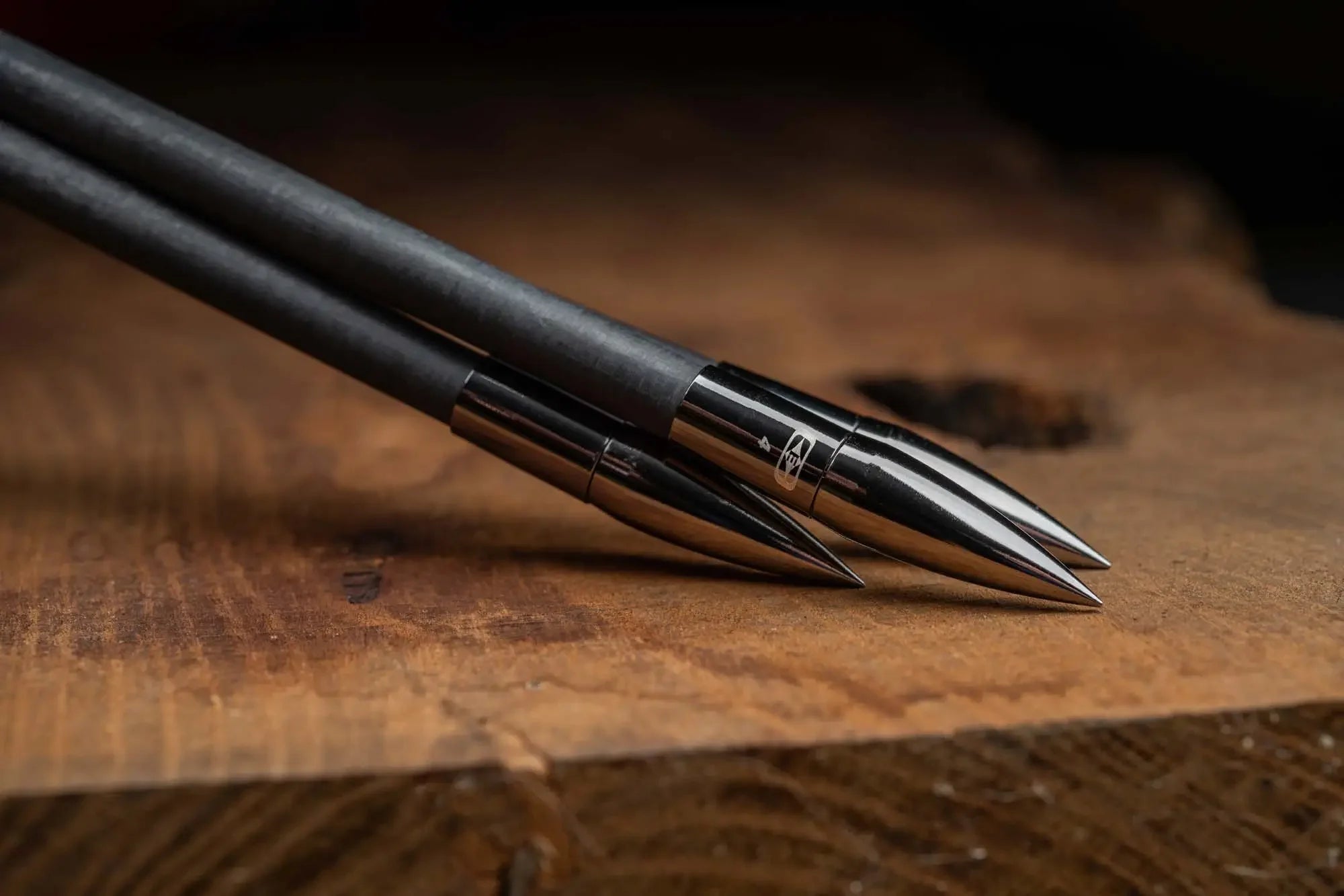 Black match grade collar with metallic bullet tip design on wood surface