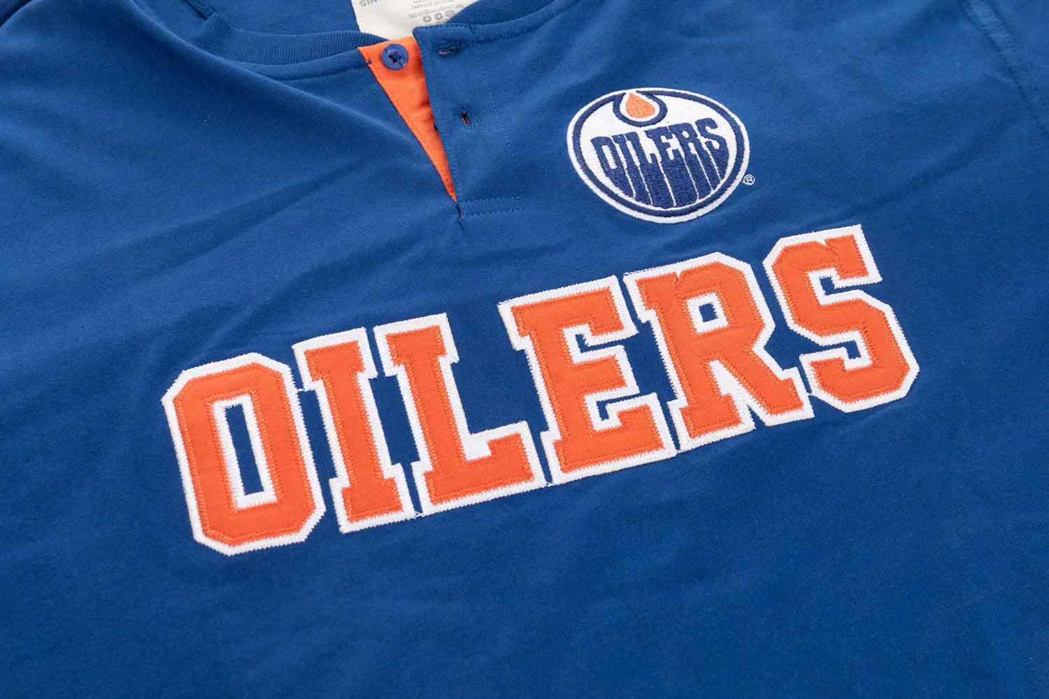 Blue Edmonton Oilers henley shirt with team logo and bold orange OILERS text