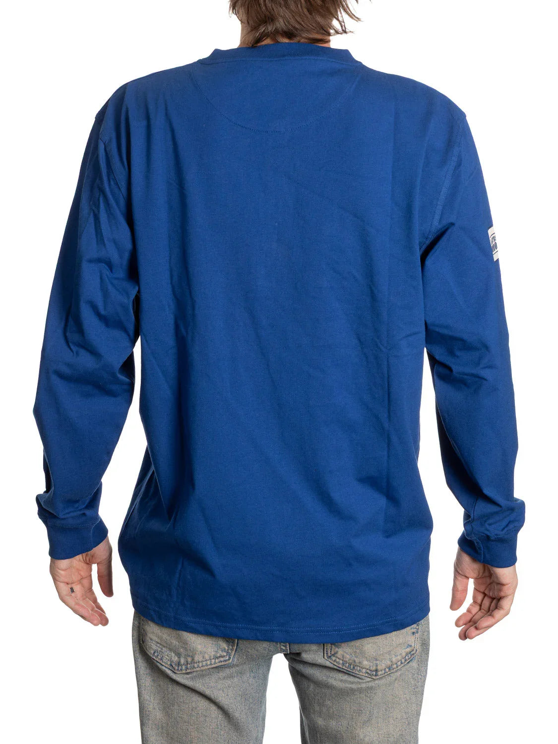 Back view of person wearing blue long sleeve Henley shirt and light jeans