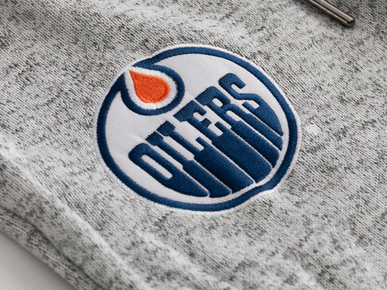 Edmonton Oilers logo patch on grey Muskoka sweatpants fabric with zipper detail