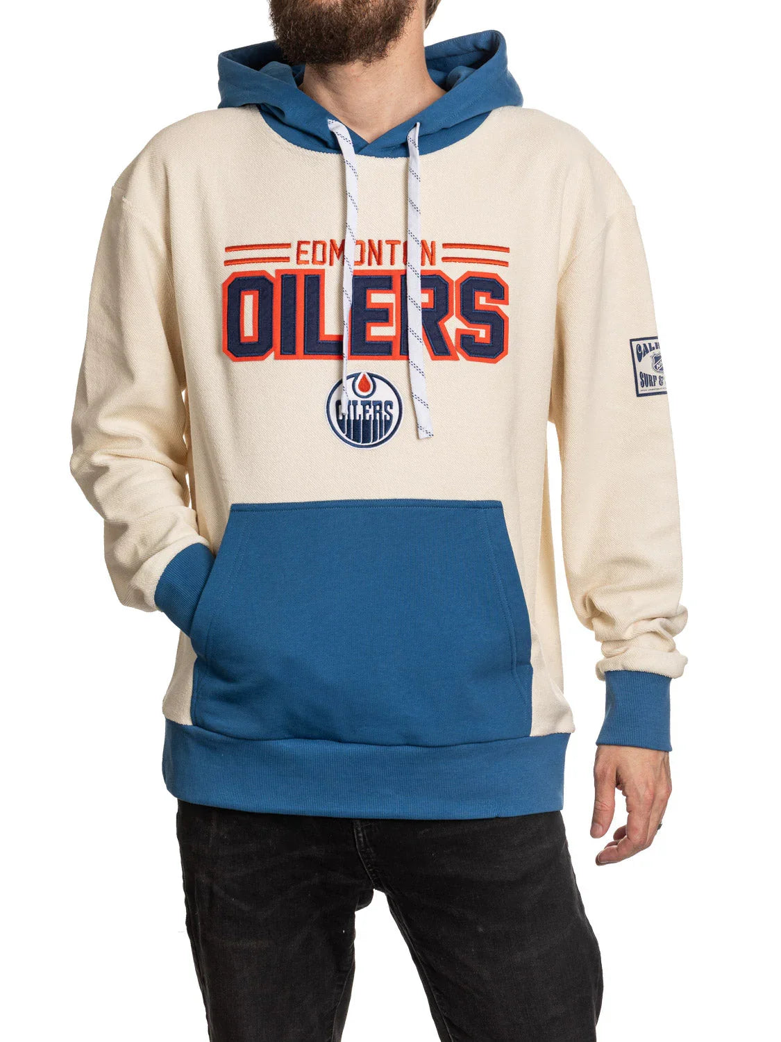 Man wearing Edmonton Oilers cream and blue hoodie with team logo and front pocket