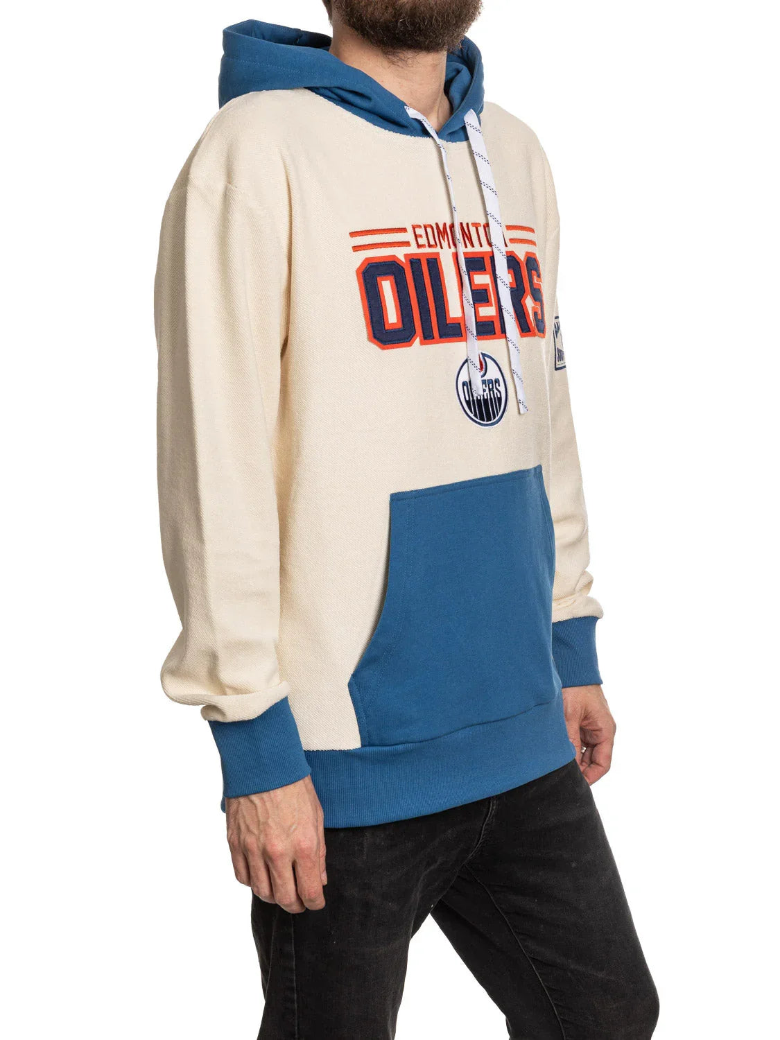 Man wearing cream and blue Edmonton Oilers hoodie with team logo and front pocket