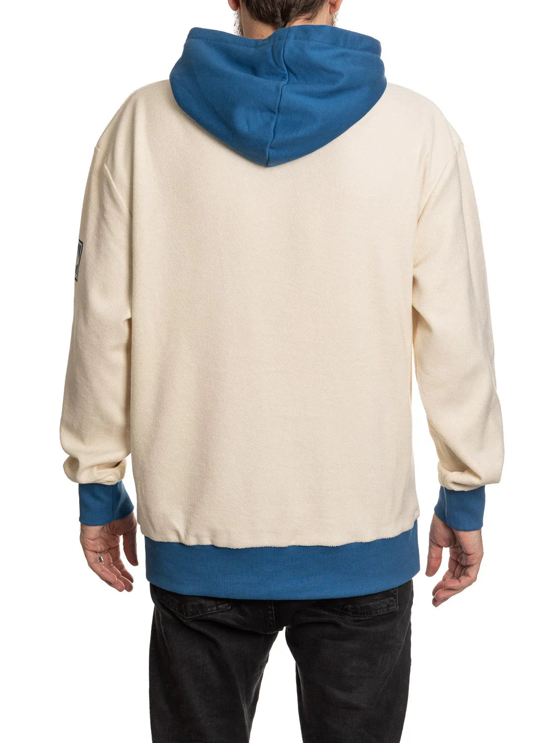 Back view of man wearing cream hoodie with blue hood, cuffs, and hem, casual fashion