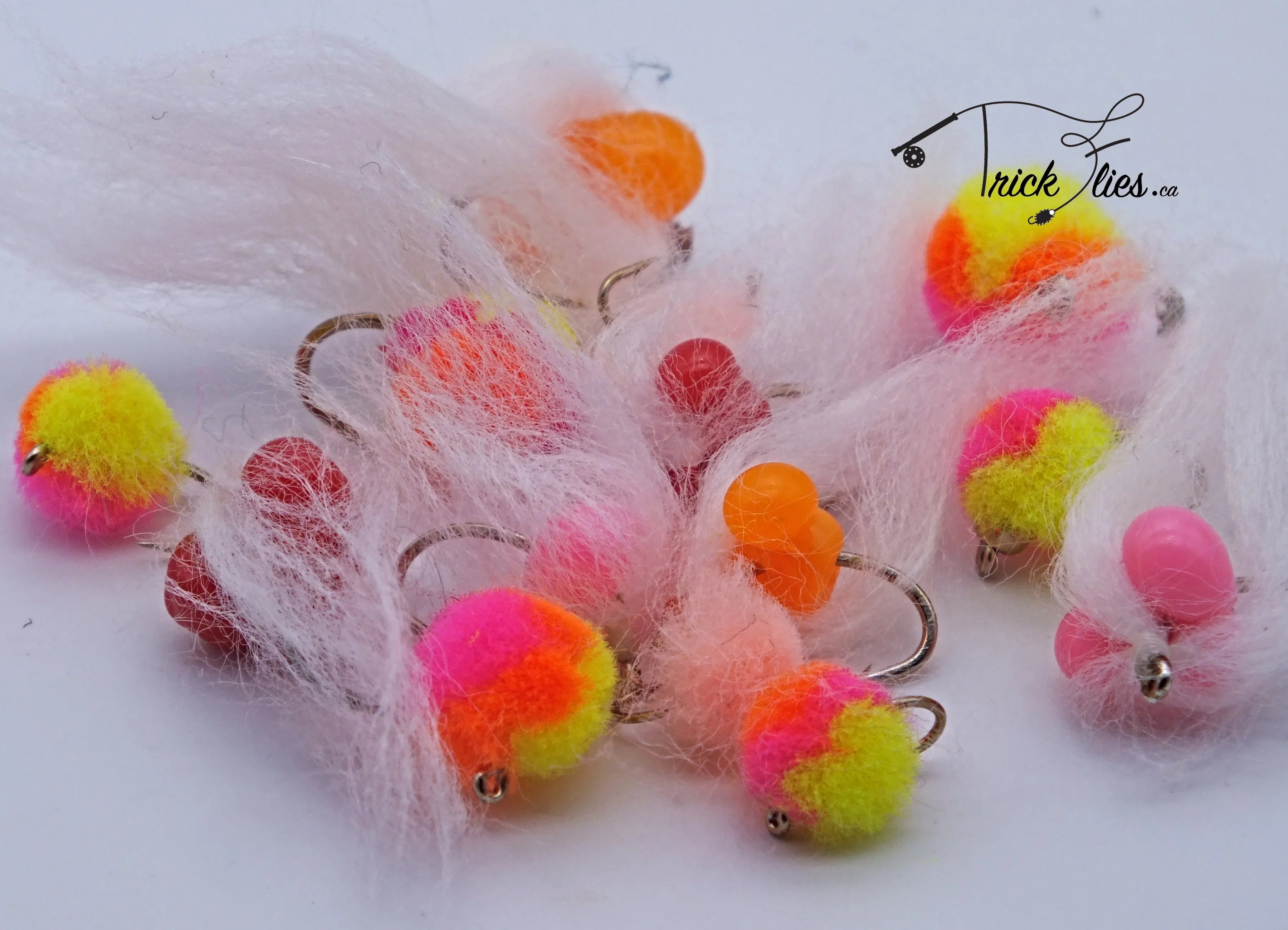 Colorful egg pattern fly fishing lures with white fibers on a white background