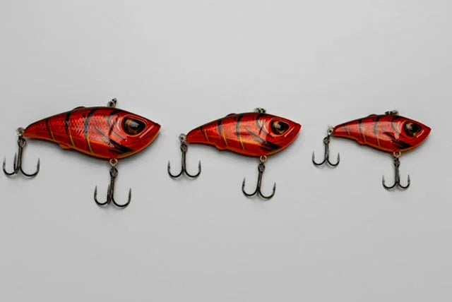 Three red and black striped fishing lures with treble hooks on a white background.