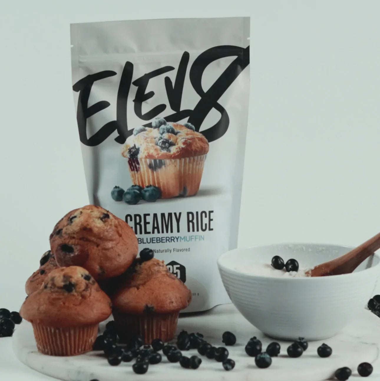 ELEVEN8 Creamy Rice Blueberry Muffin mix with blueberry muffins and a bowl of creamy rice