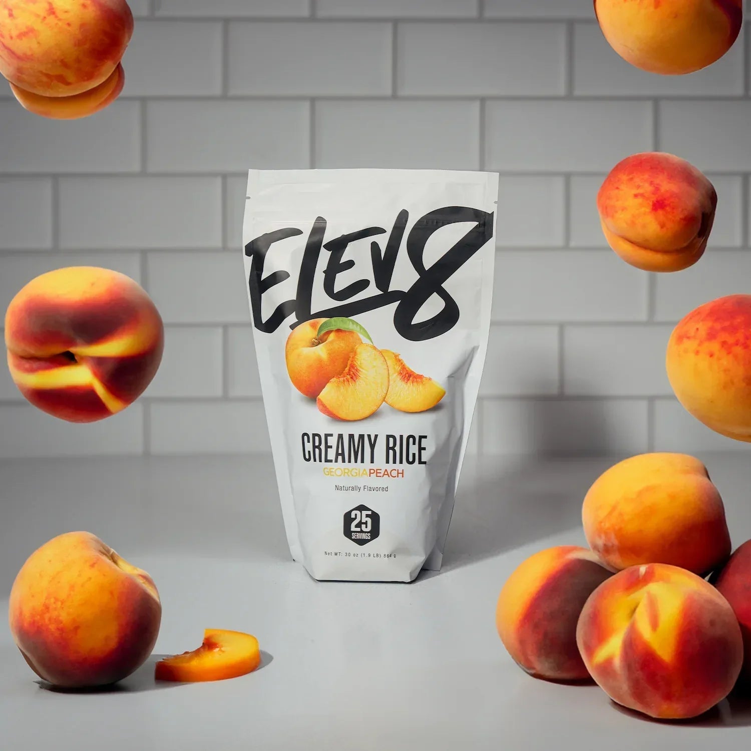 Elev8 Creamy Rice Georgia Peach flavor pouch with fresh peaches on a kitchen counter