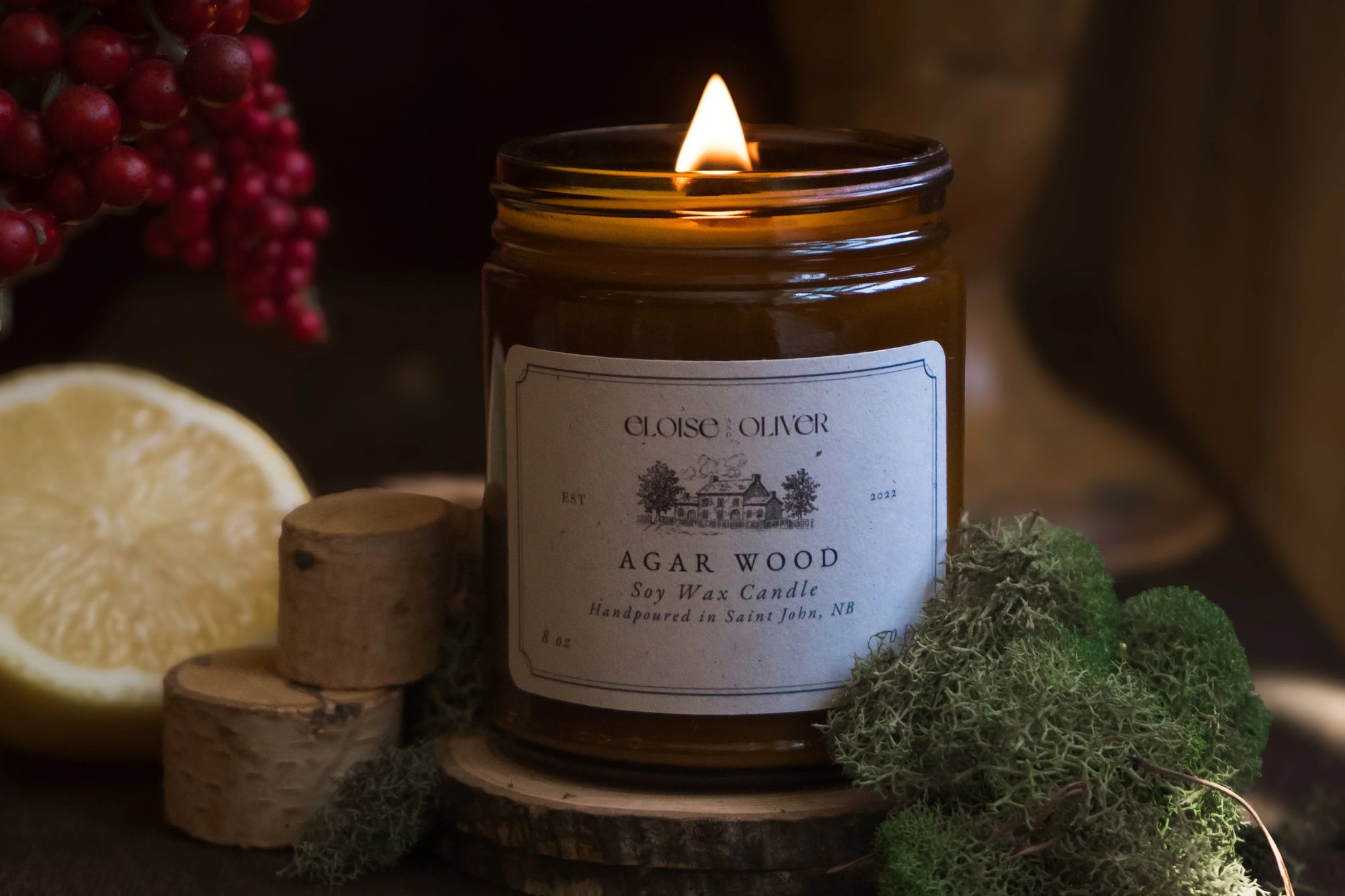 Agar wood soy wax candle by Eloise & Oliver in amber jar with moss, birch wood, lemon, and berries
