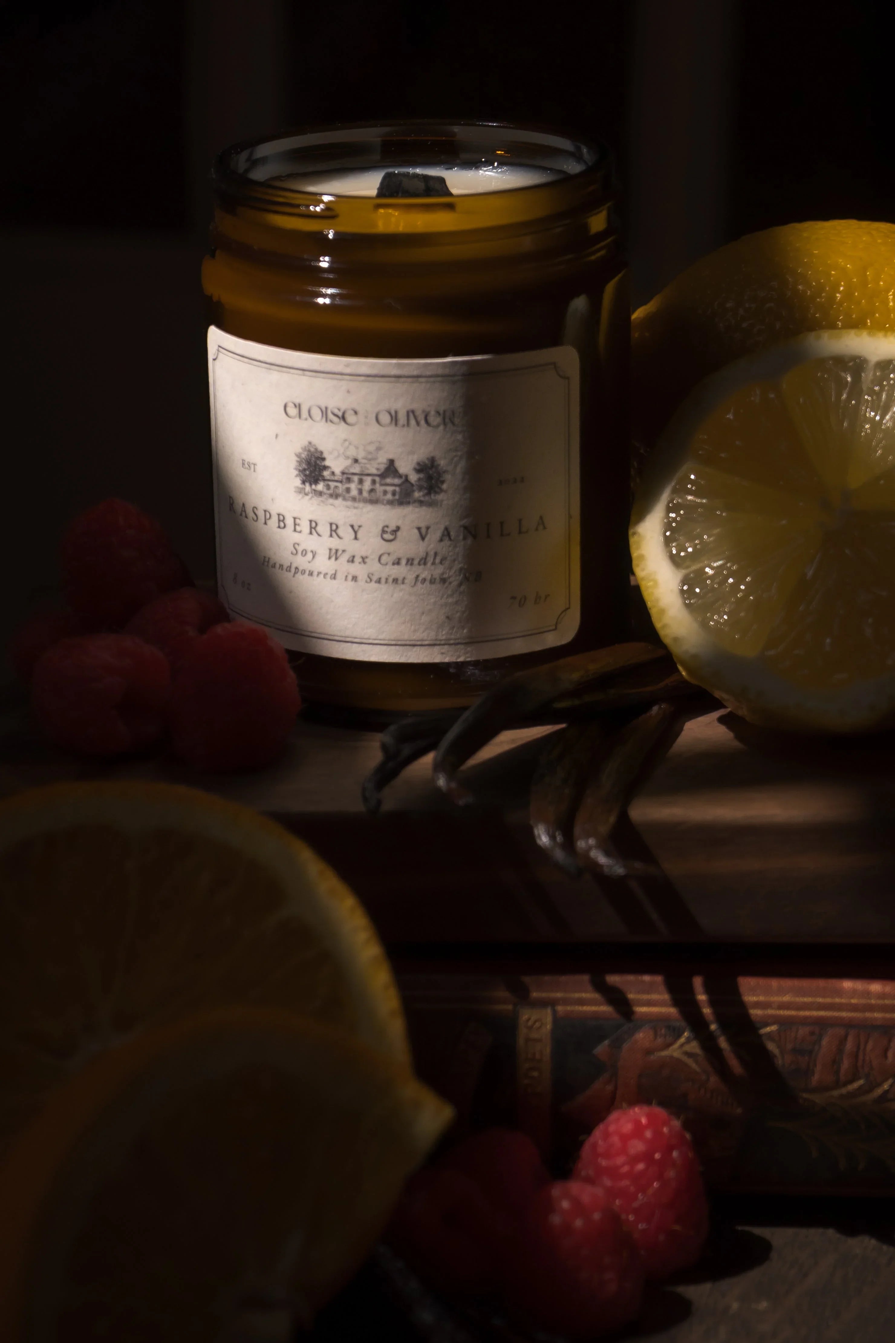 Raspberry and vanilla soy wax candle with fresh raspberries, lemons, and vanilla beans