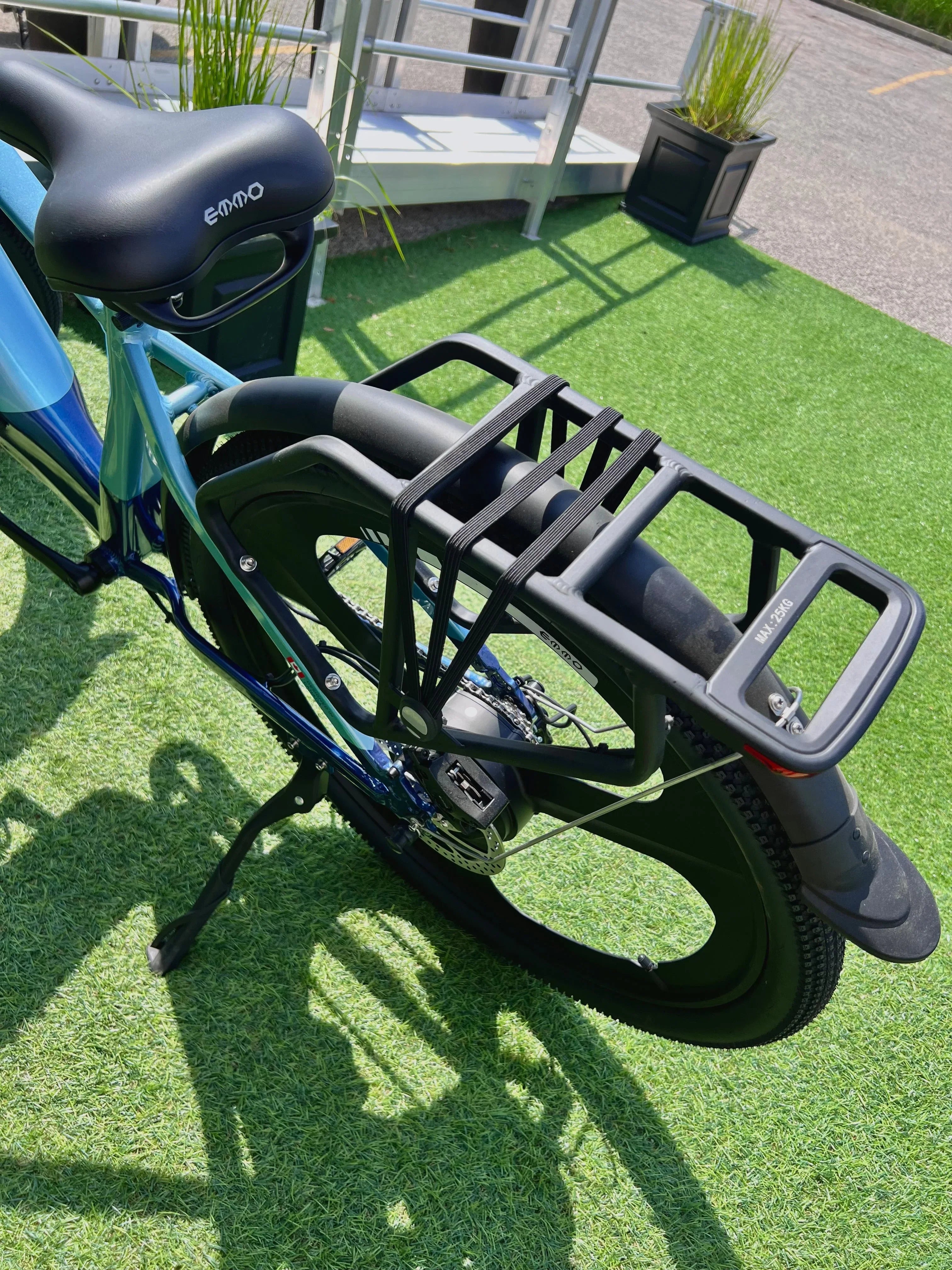 Emmo electric bike rear rack and tire on green artificial grass outdoors