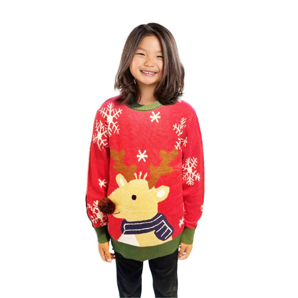 Smiling child in red Christmas sweater with reindeer and snowflake design on white background